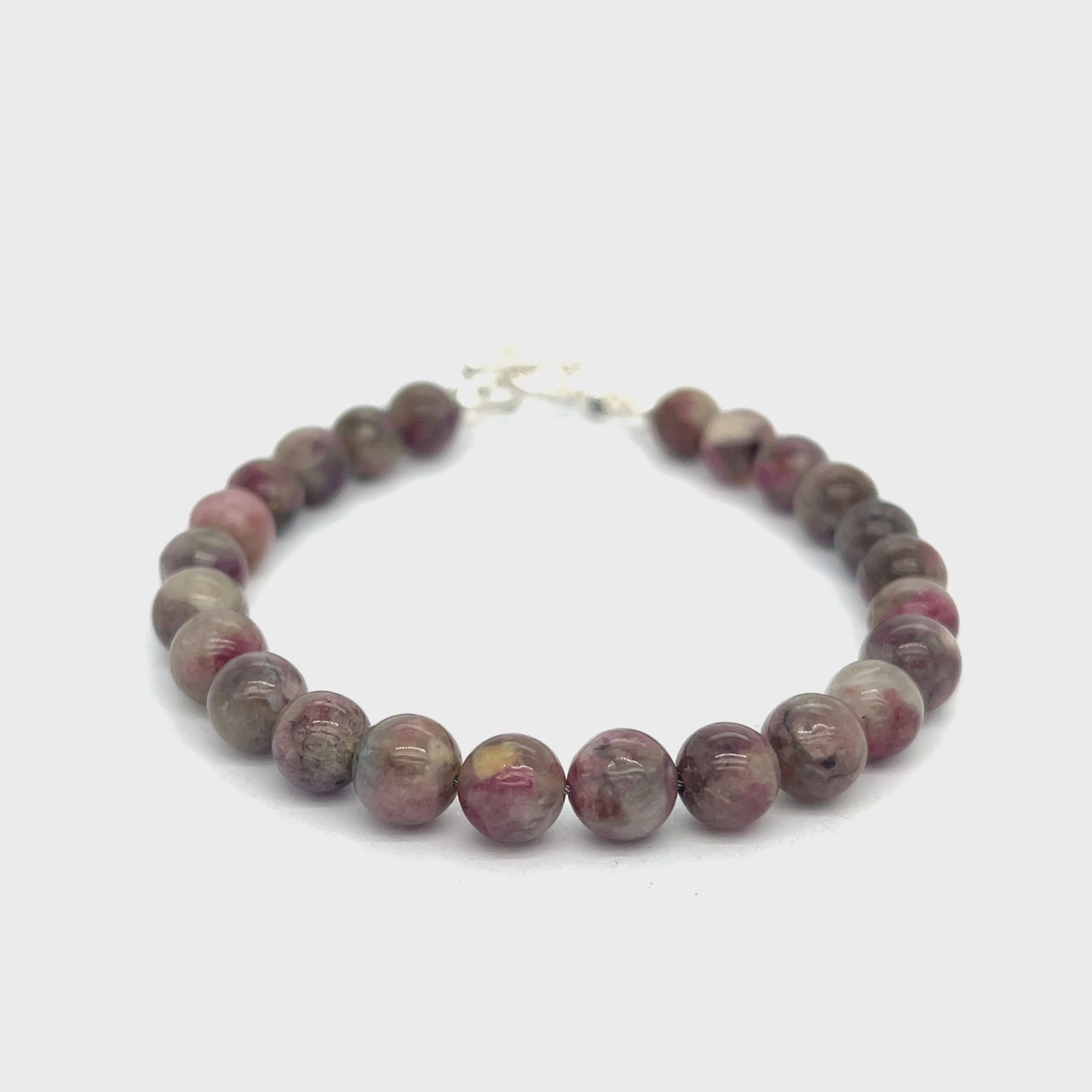 A Eudialyte gemstone beaded bracelet with a sterling silver toggle on a white background front overview video