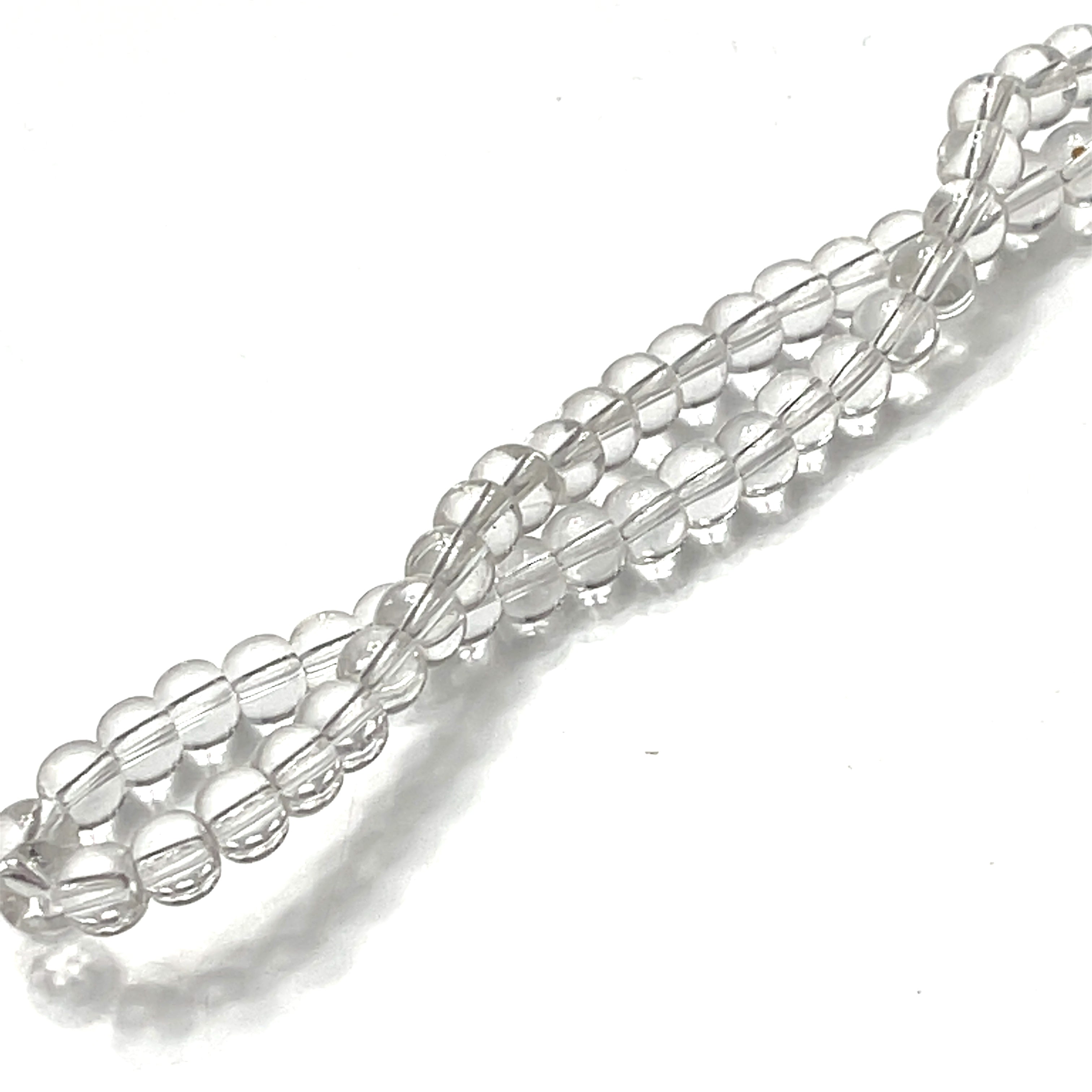 3mm Clear Quartz gemstone smooth rounds strand on a white background, overview. 