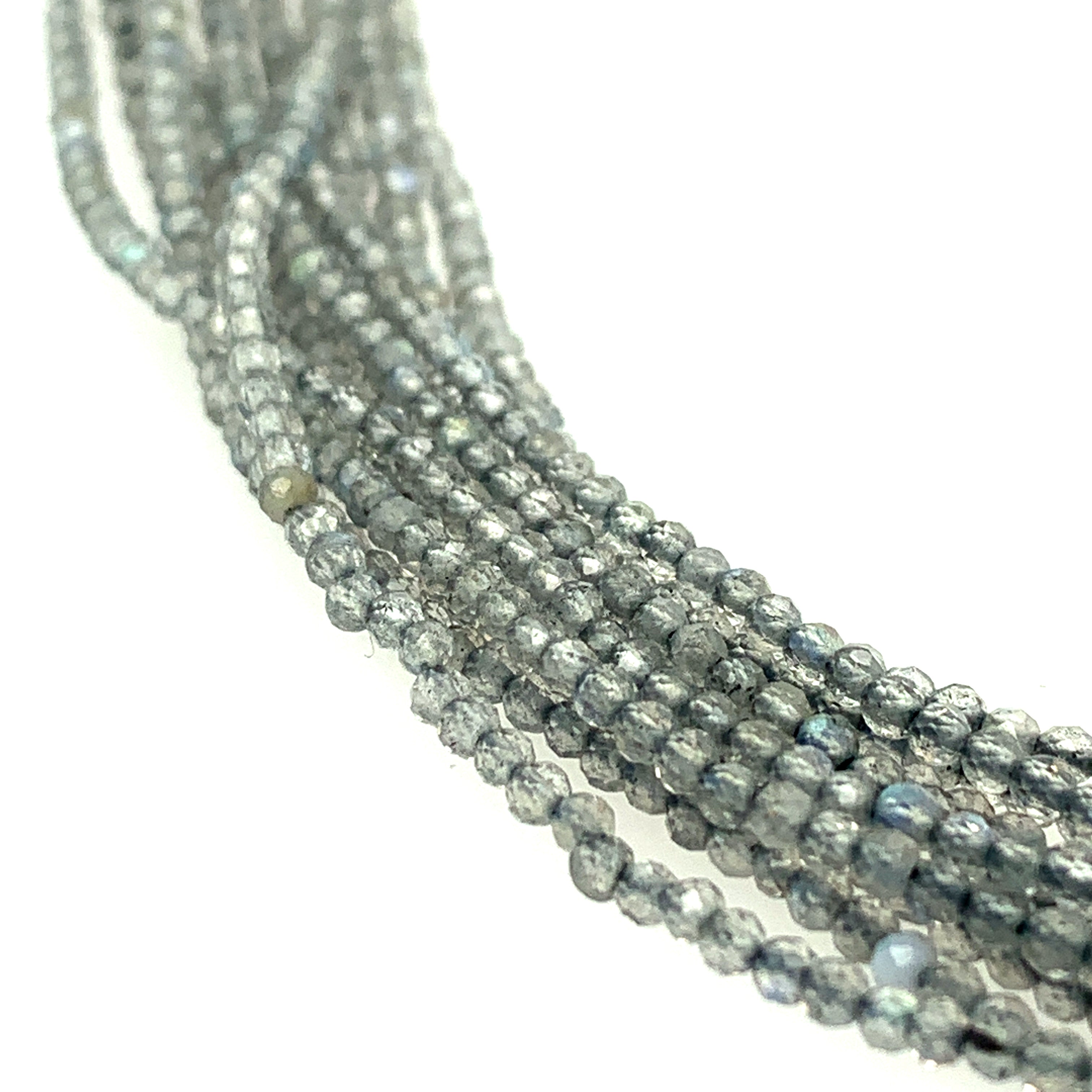 3mm faceted roundel  Labradorite beads on a white background, front overview.