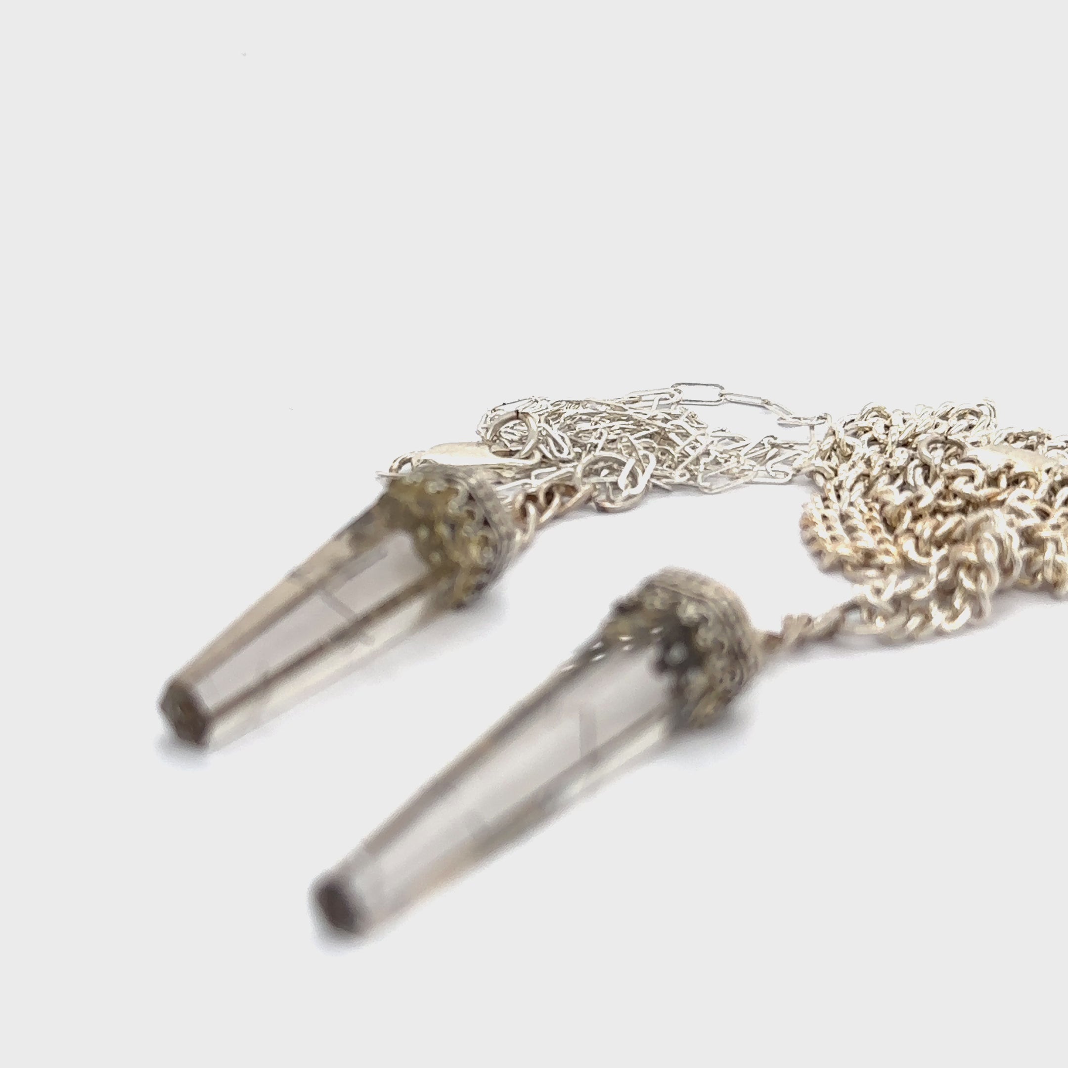 Two Rutilated Quartz pendants on a Sterling Silver chain necklace with intricate designs on the bezel caps on a white background, diagonal long view. video