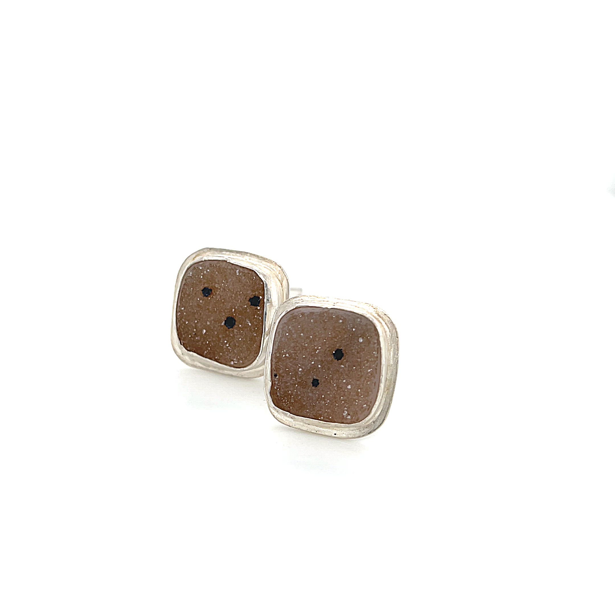 Close-up of natural quartz crystal druzy texture with brown inclusions gemstone with sterling silver cufflinks on a white background slight right angle overview. video