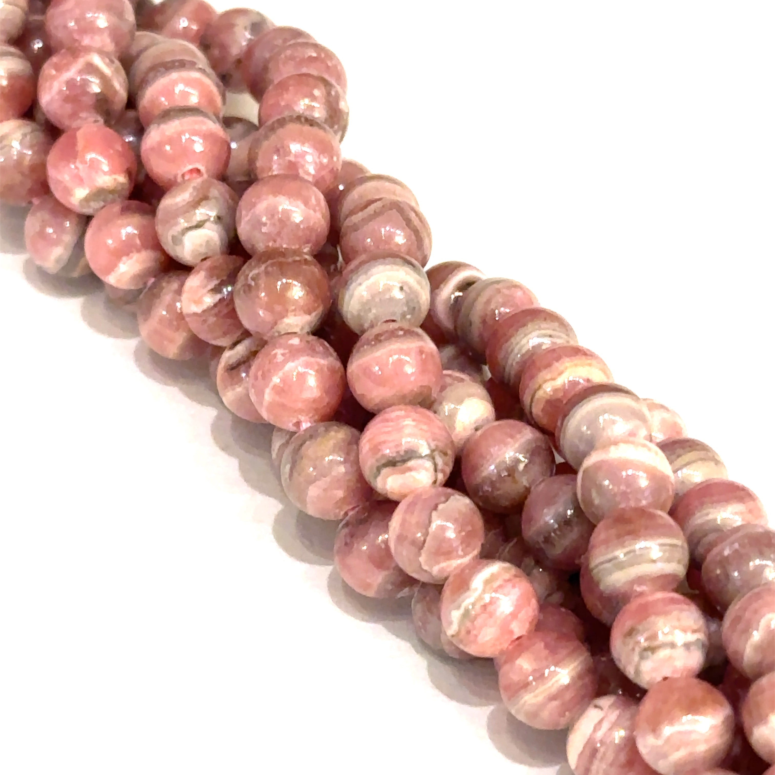 6mm Rhodochrosite smooth round gemstone strand on a white background, front overview.