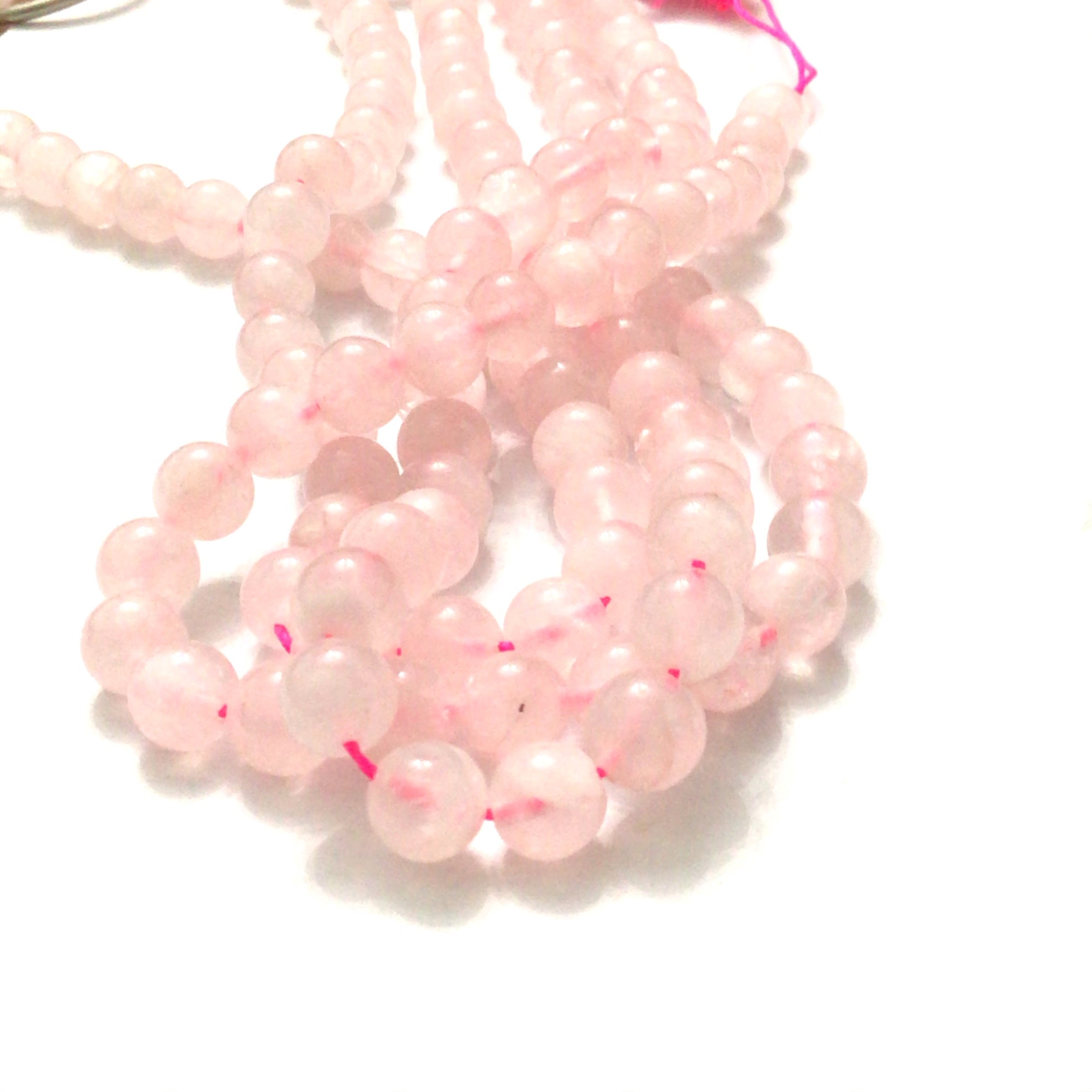 6mm Rose Quartz gemstone beads, smooth round, 16'' strand on a white background, front overview.