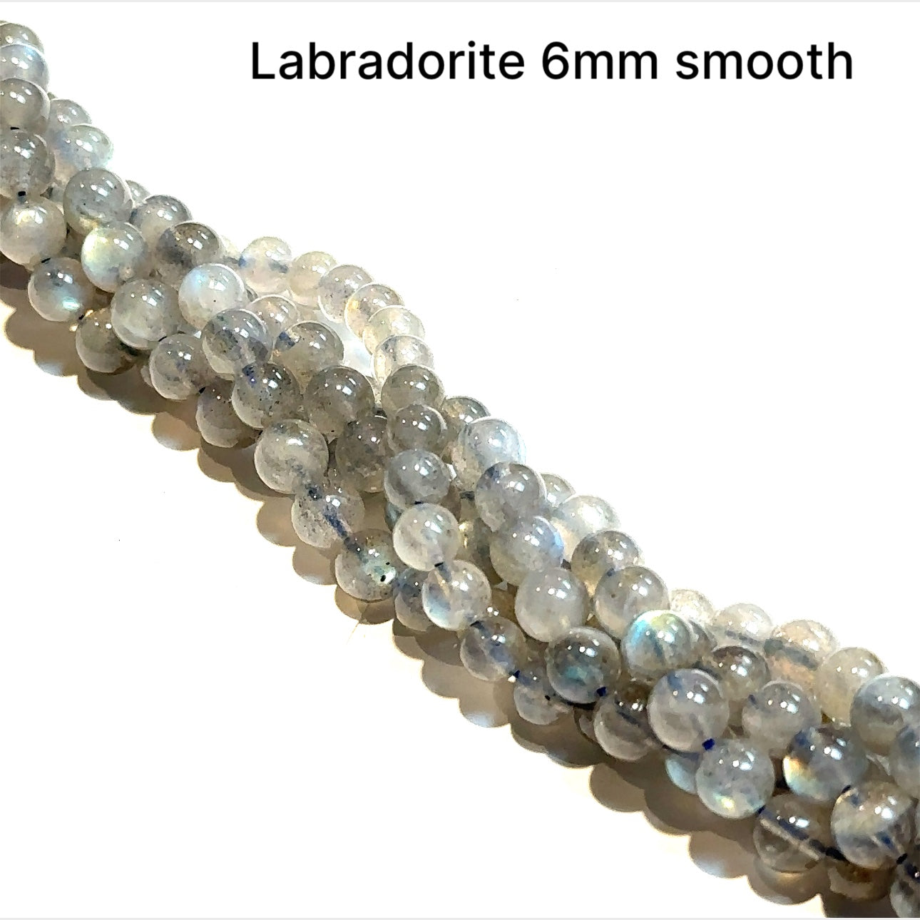 6mm smooth round  Labradorite beads on a white background, front overview.