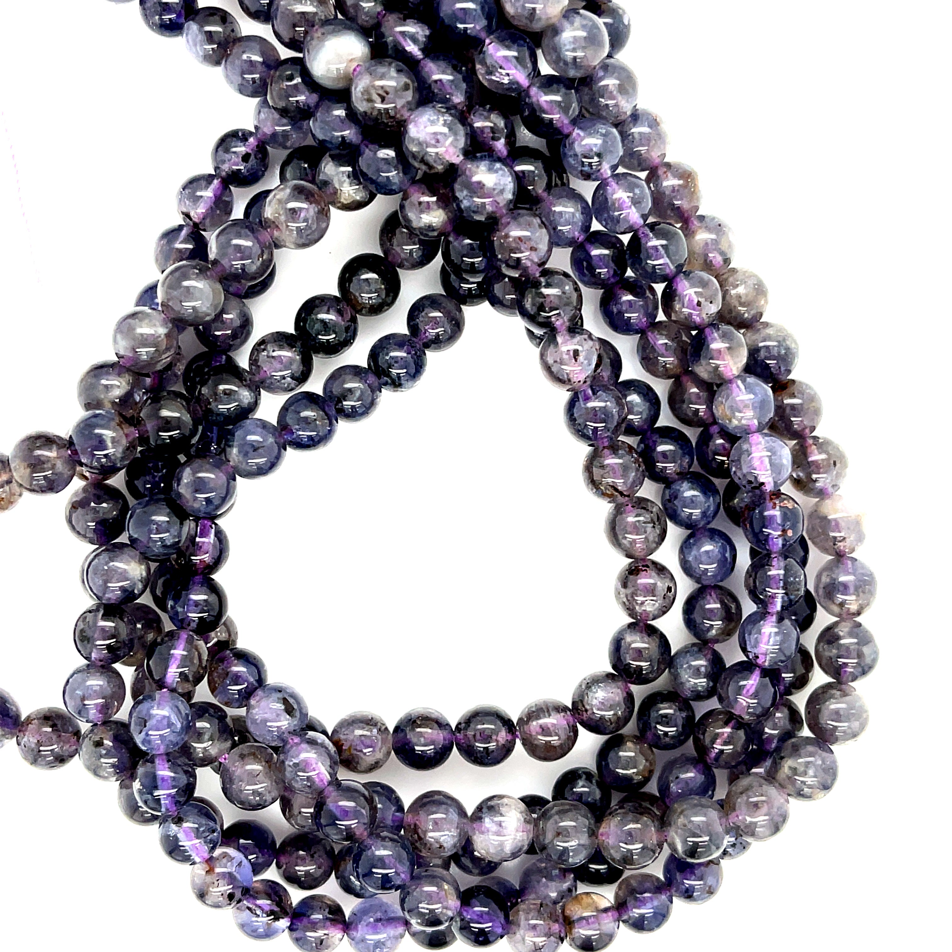 6mm smooth round Natural iolite gemstone strand in deep blue for third eye chakra activation and intuition on a white background, front over view. 