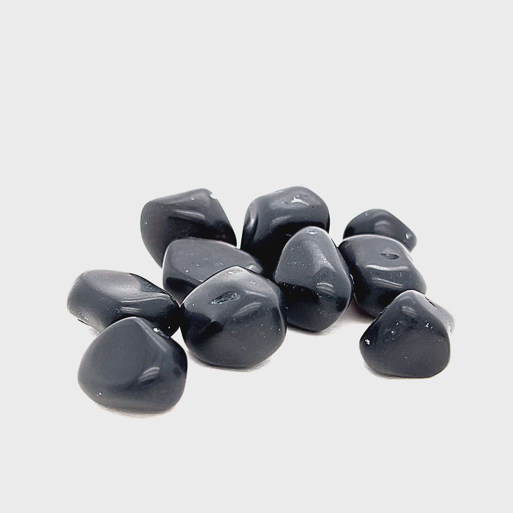 A collection of Apache Tear tumbled gemstones on a white background, front overview. video