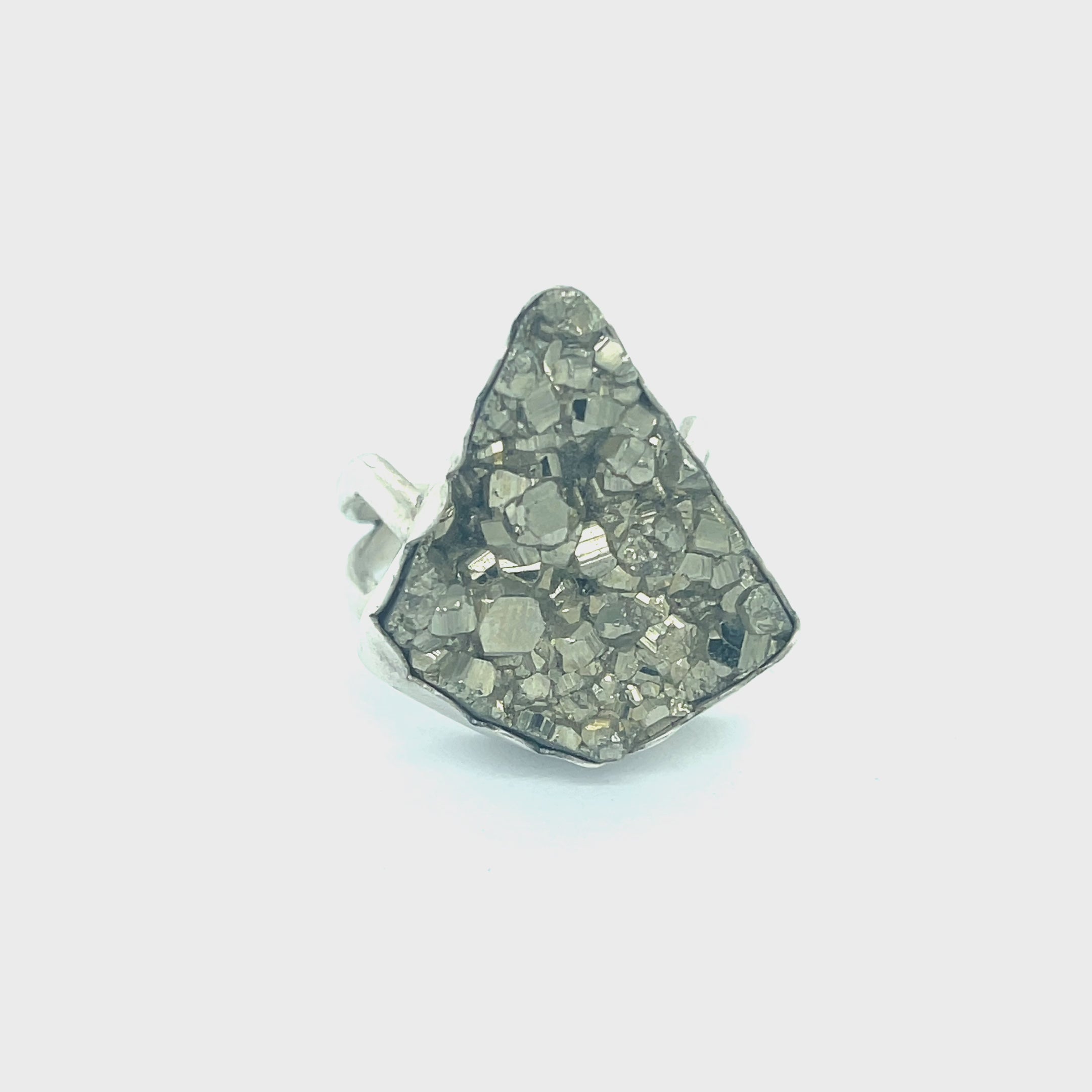 Statement Pyrite ring in scalloped bezel setting — handmade gemstone jewelry on a white background front slight right angle view. video