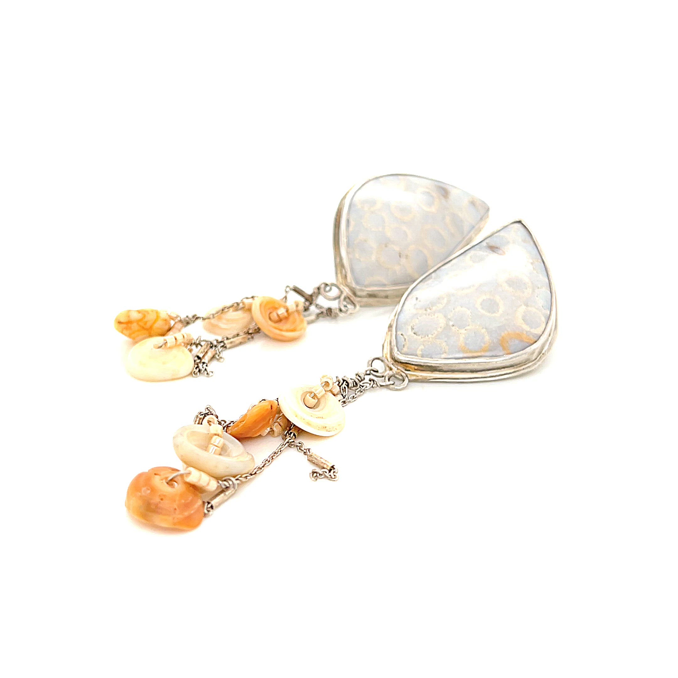Genuine fossil coral earrings in sterling silver with flower-like patterns on a white background slight right diagonal front overview.  video