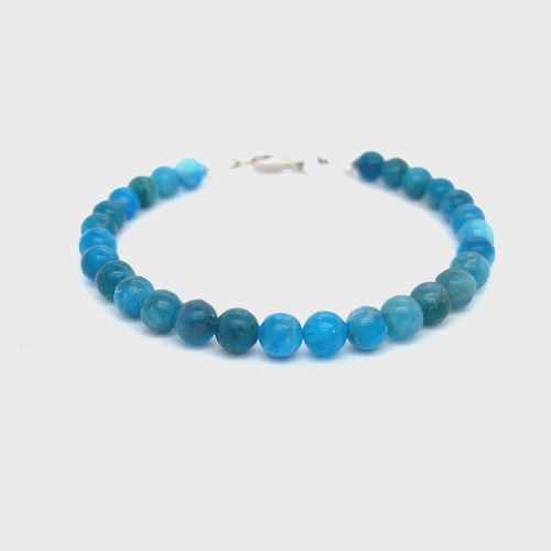 A blue Apatite beaded gemstone bracelet with silver lobster claws, displayed against a white background, front overview video.