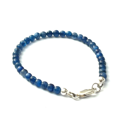 A Blue Kyanite beaded gemstone bracelet with a sterling silver lobster claw clasp. On a white background, back left angle overview.