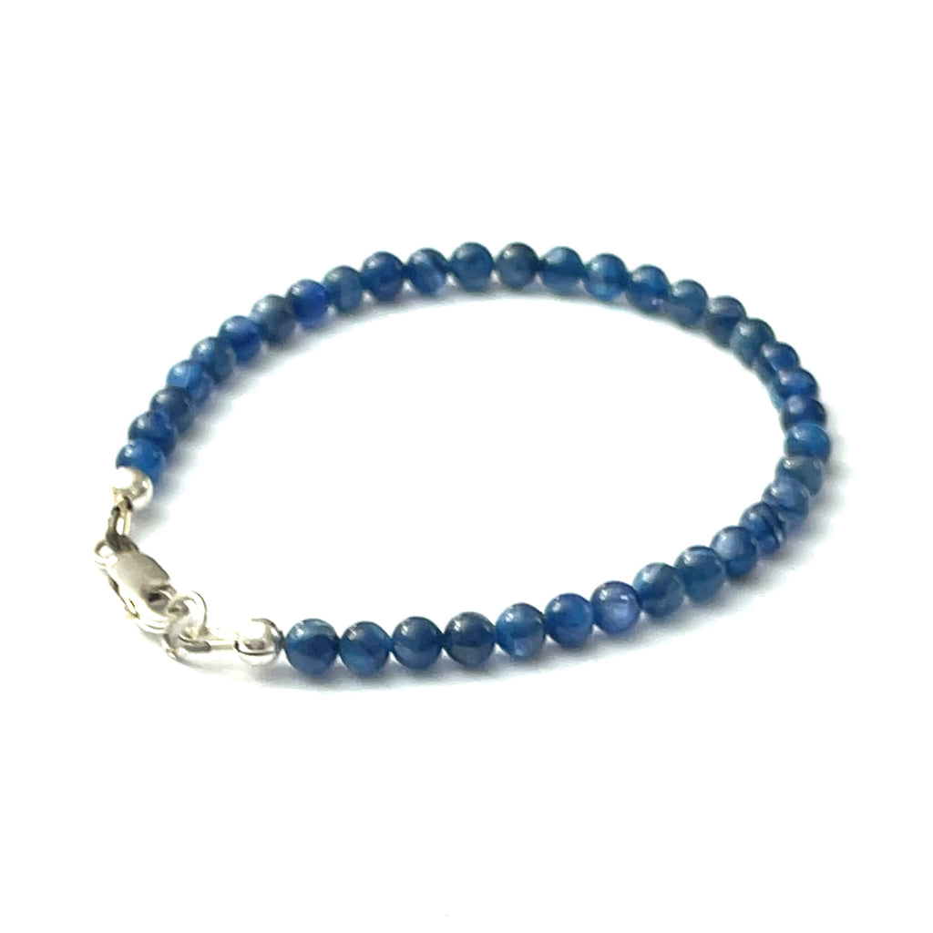 A Blue Kyanite beaded gemstone bracelet with a sterling silver lobster claw clasp. On a white background, back right angle overview.