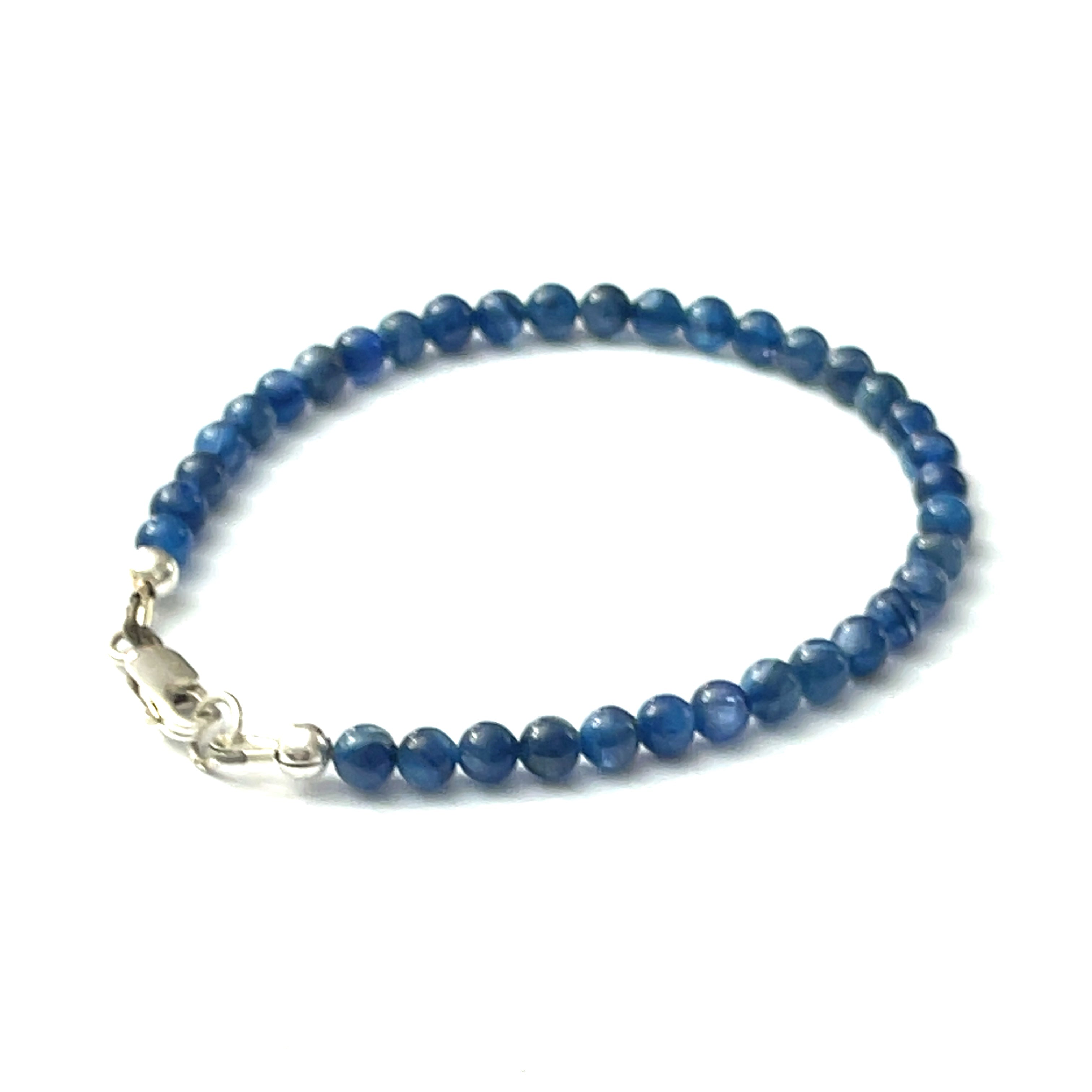 A Blue Kyanite beaded gemstone bracelet with a sterling silver lobster claw clasp. On a white background, back right angle overview.