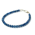 A Blue Kyanite beaded gemstone bracelet with a sterling silver lobster claw clasp. On a white background, front left angle overview.
