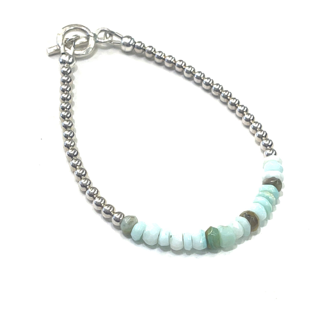 A  Blue Opal gemstone bracelet with sterling silver toggle handmade by Hidden Jewel on a white background slight right angled overview.