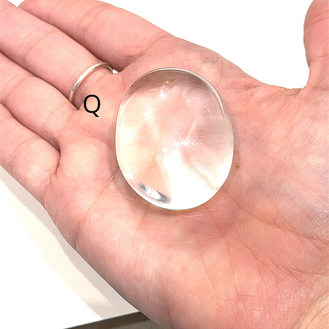 A Brazilian Lodolite Garden Quartz palm gemstones, labeled Q is displayed on a white background in a front view. 