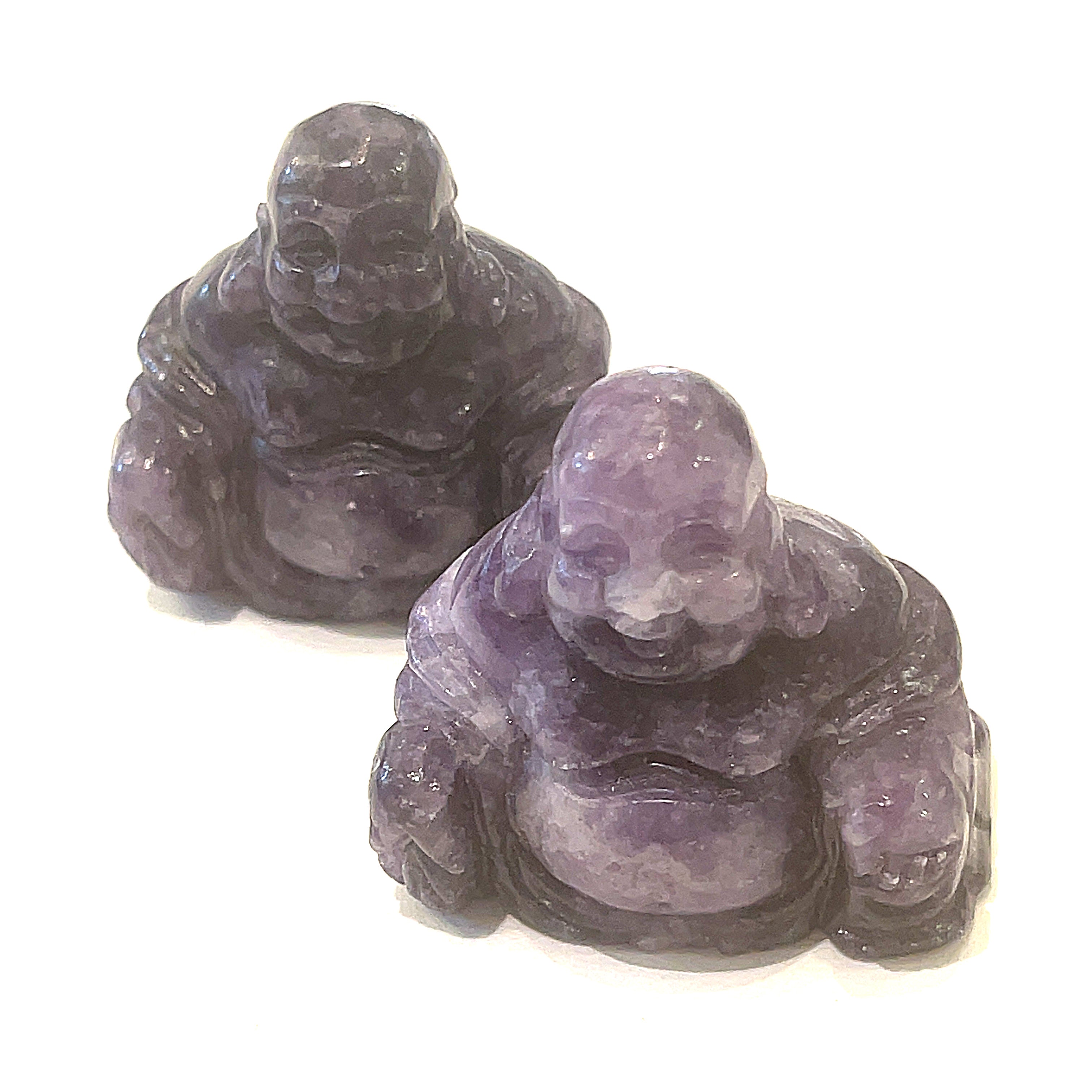 A Close-up of Amethyst of a Reiki infused gemstone Buddha with detailed carving on a white background front overview. 