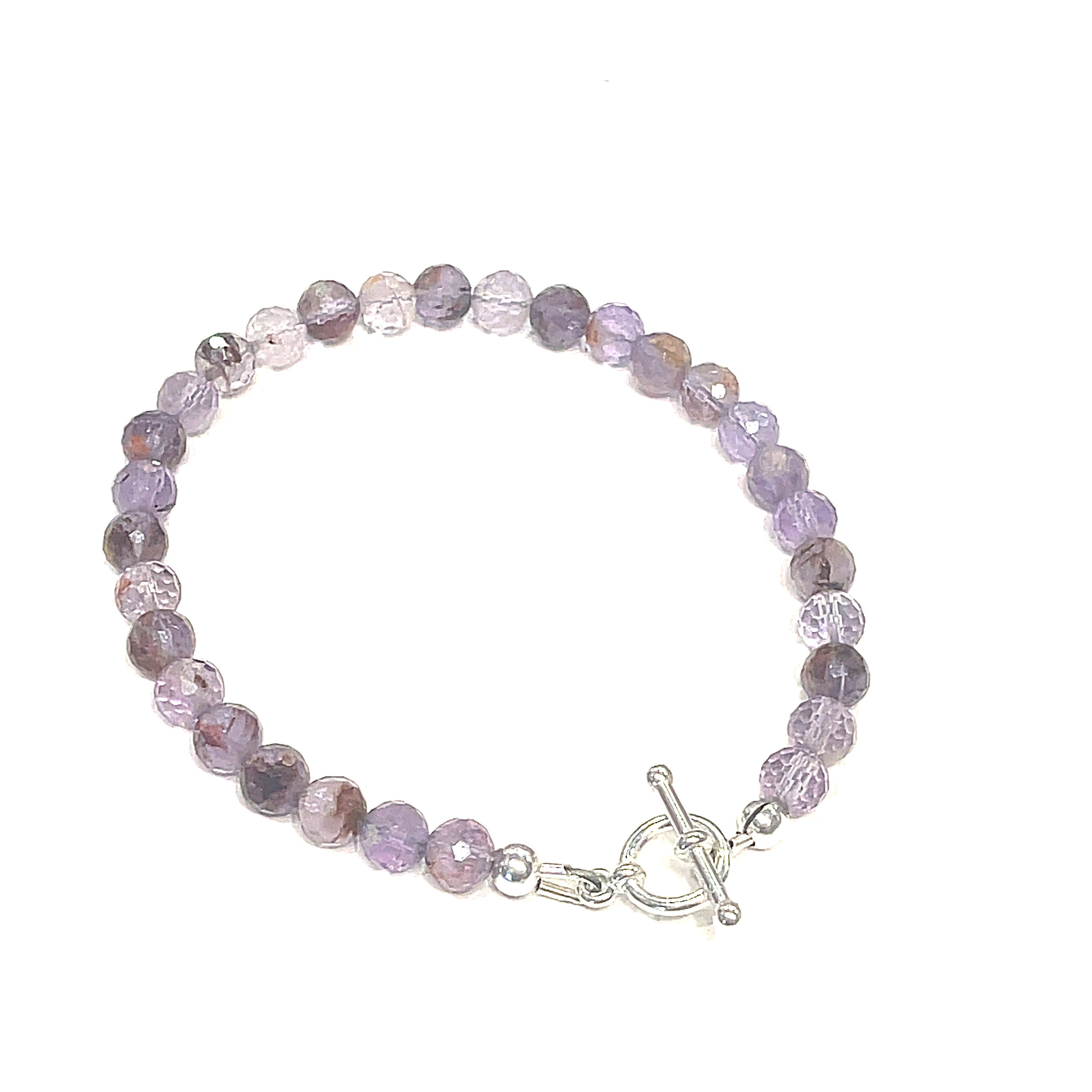 A Close-up of the Super Seven gemstone bracelet with 6mm faceted beads and a sterling silver toggle clasp. On a white background, front right angle view. 