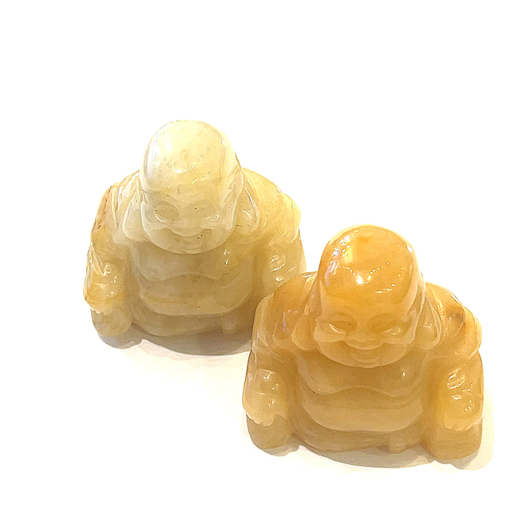 A Close-up of  yellow jade  of a Reiki infused gemstone Buddha with detailed carving on a white background front overview