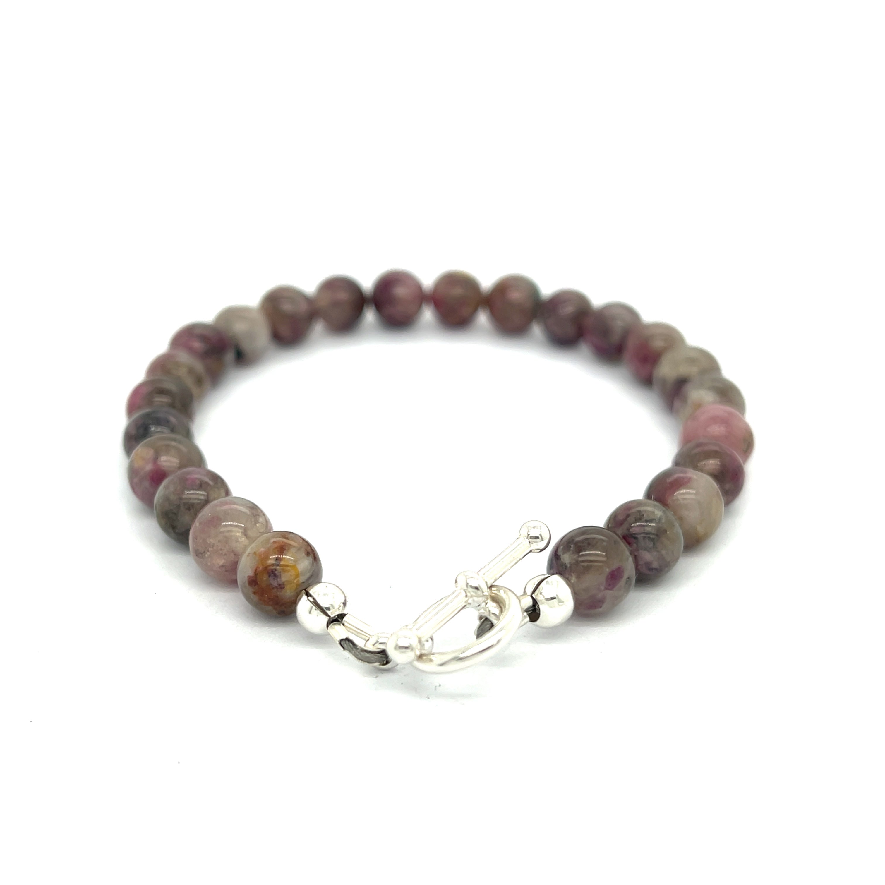 A Eudialyte gemstone beaded bracelet with a sterling silver toggle on a white background back center overview.