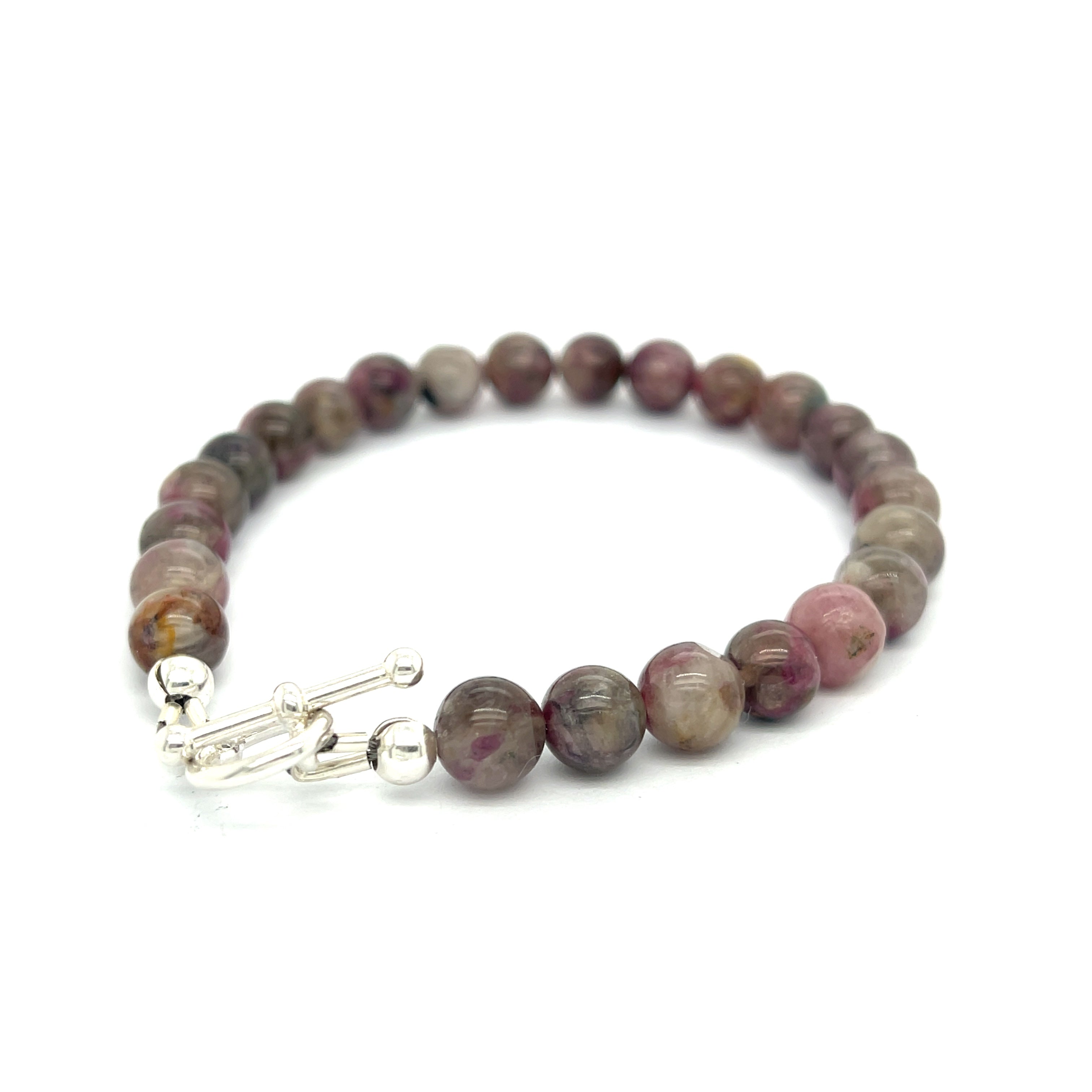 A Eudialyte gemstone beaded bracelet with a sterling silver toggle on a white background back left angle overview.