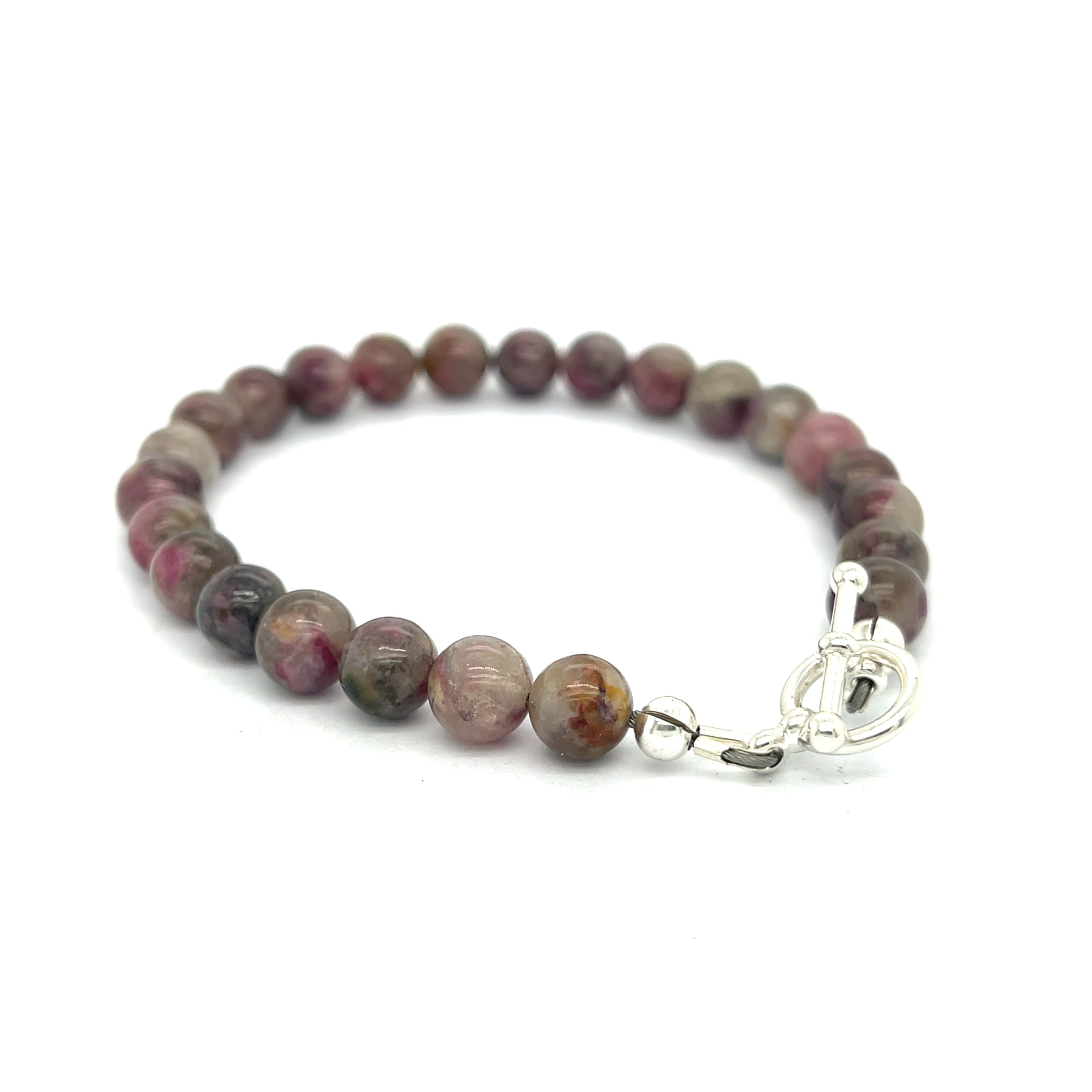A Eudialyte gemstone beaded bracelet with a sterling silver toggle on a white background back right angle overview.
