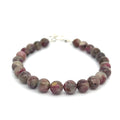 A Eudialyte gemstone beaded bracelet with a sterling silver toggle on a white background front overview.