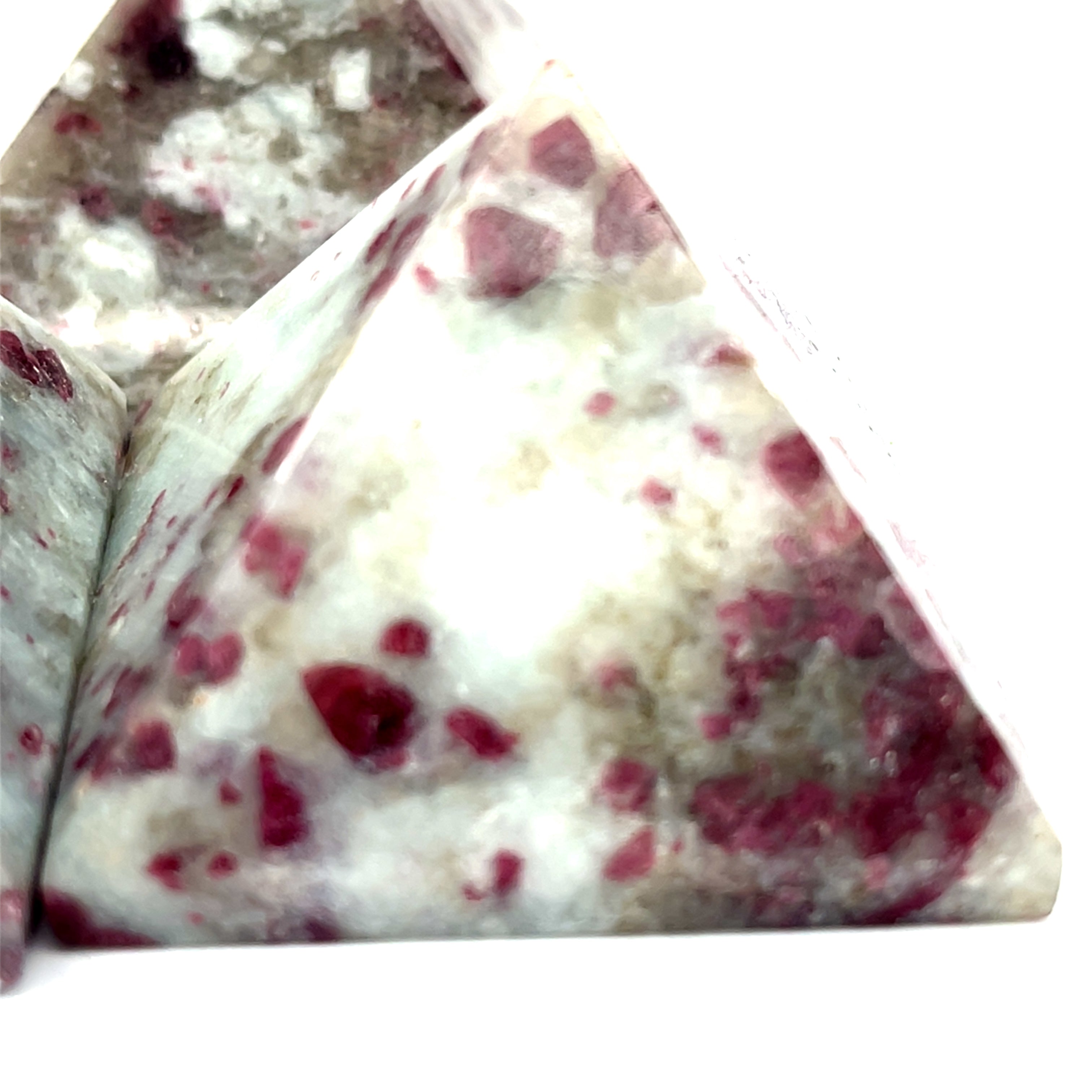 A Pink Tourmaline Pyramid used for heart chakra meditation and energy healing on a white background front close up overview.