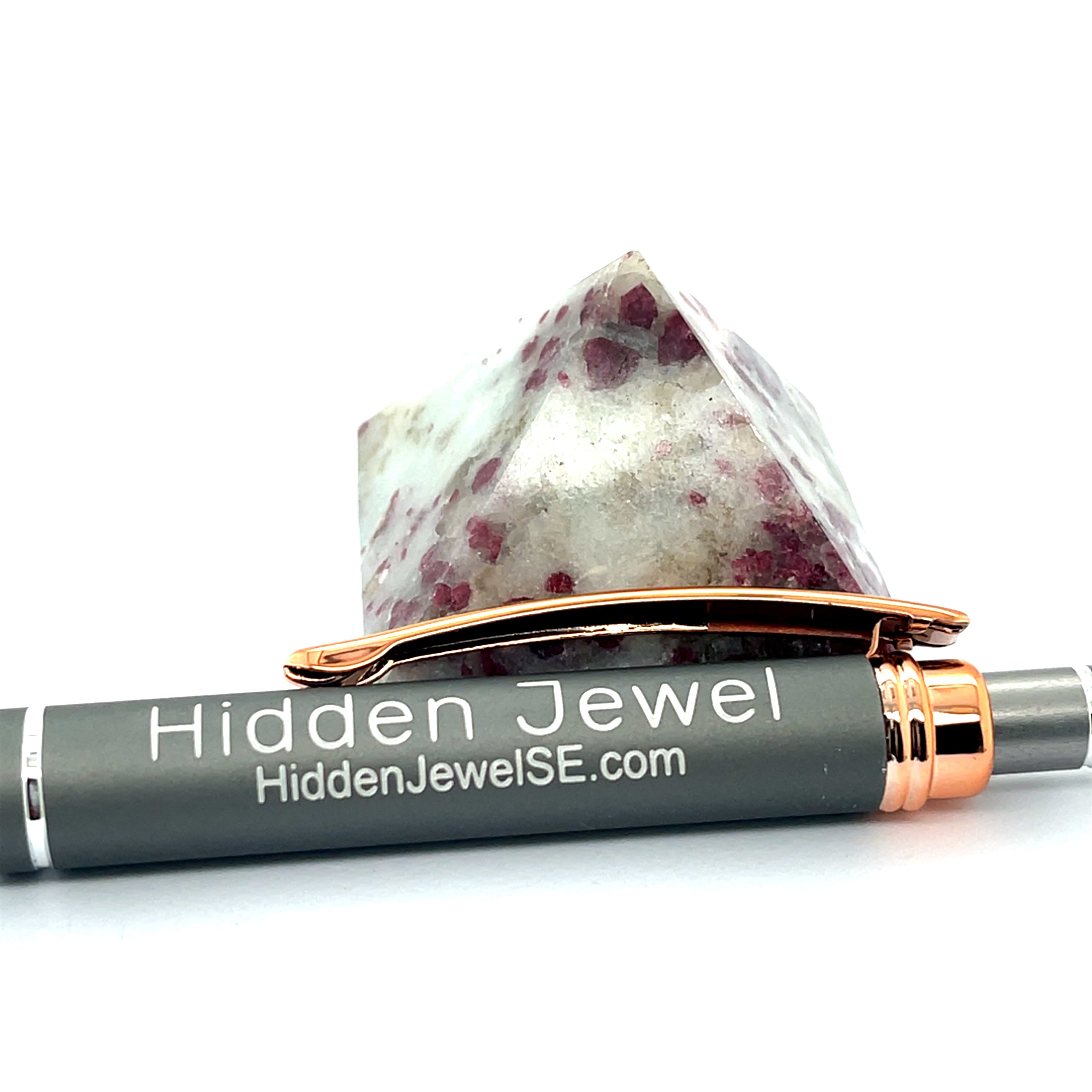 A Pink Tourmaline Pyramid used for heart chakra meditation and energy healing on a white background front overview with a pen in front for sizing. 