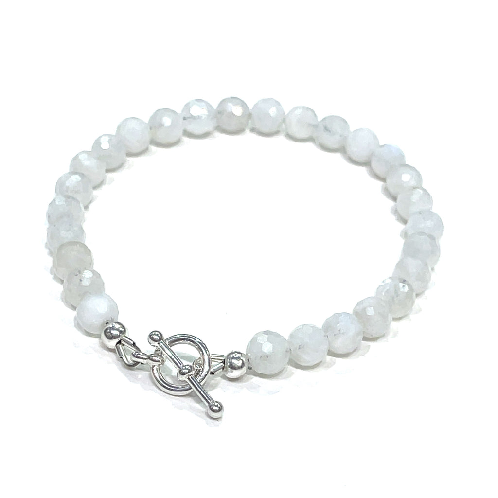 A Rainbow Moonstone beaded bracelet with a sterling silver toggle on a white background back close up overview. 