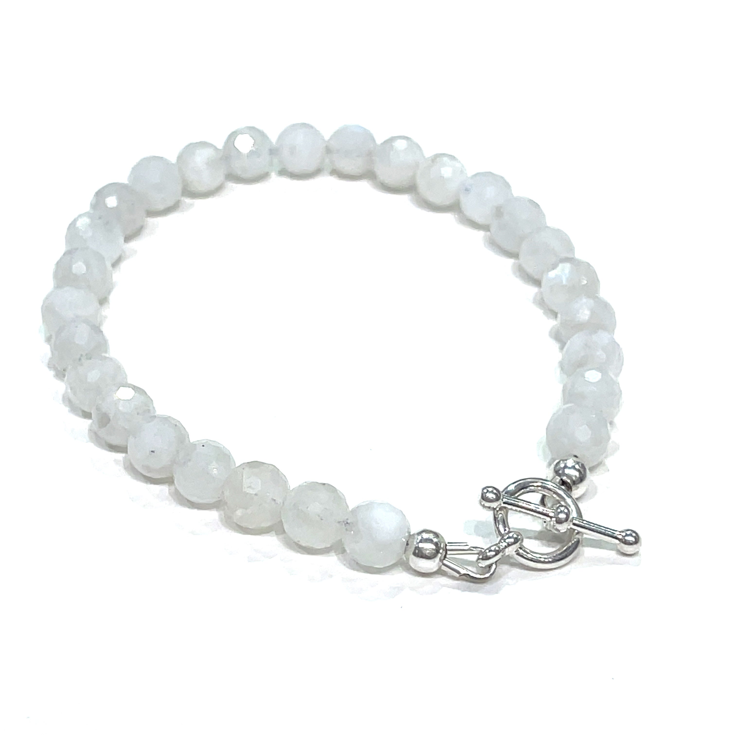 A Rainbow Moonstone beaded bracelet with a sterling silver toggle on a white background back right angle close up overview. 