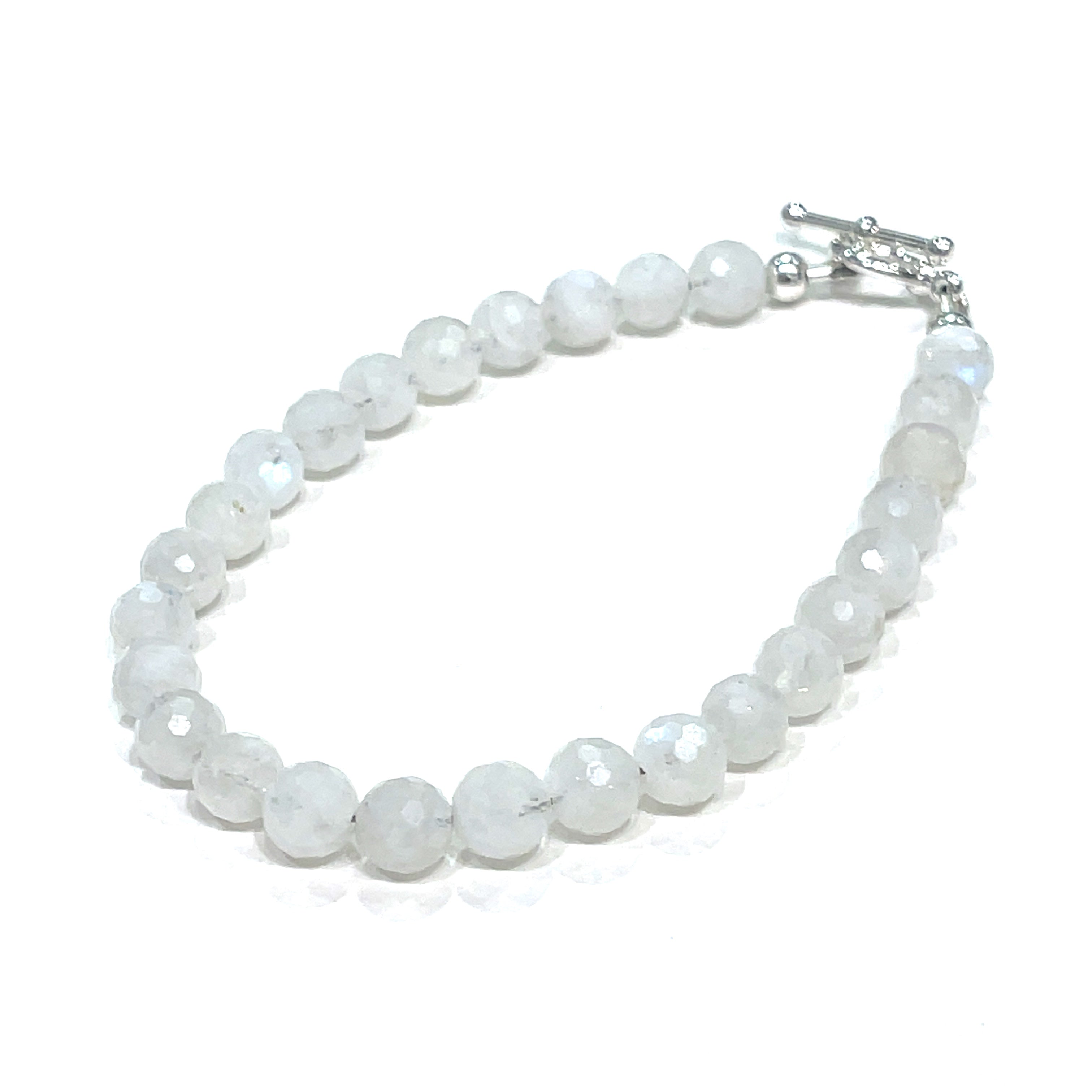 A Rainbow Moonstone beaded bracelet with a sterling silver toggle on a white background front left angle close up overview. 