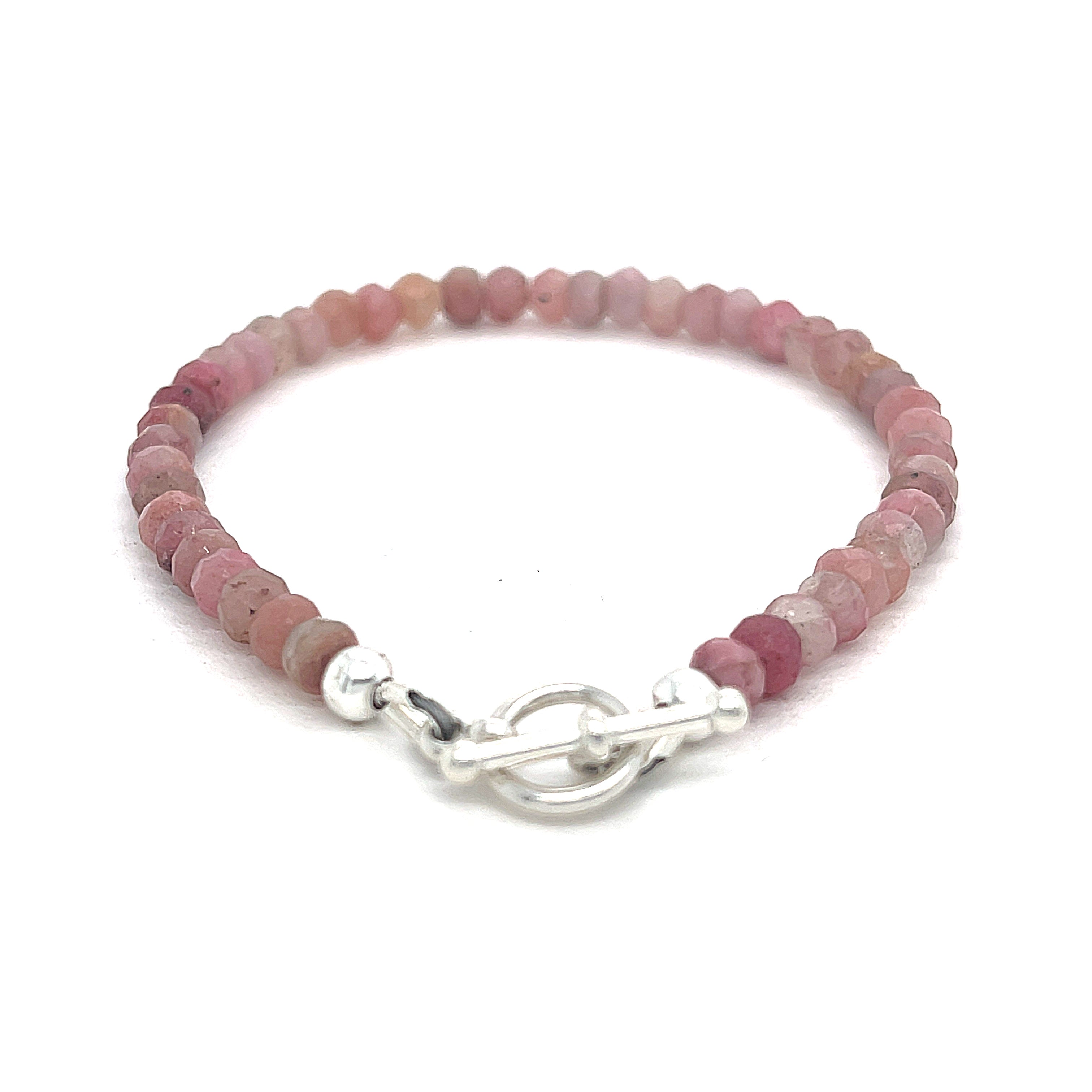 A Rhodochrosite Gemstone 3mm faceted roundel beaded bracelet with a sterling silver toggle, on a white background, back overview. 