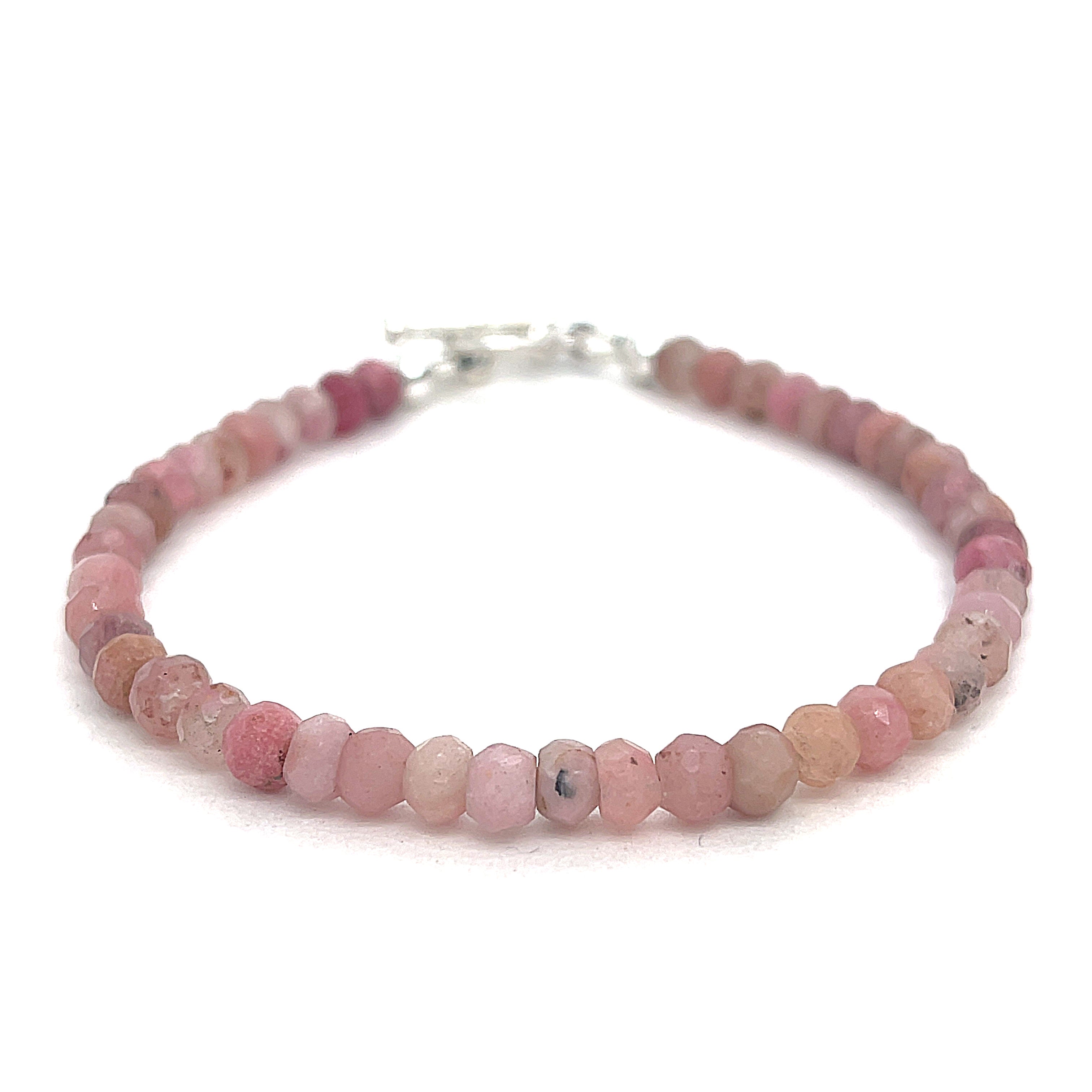 A Rhodochrosite Gemstone 3mm faceted roundel beaded bracelet with a sterling silver toggle, on a white background, front overview. 