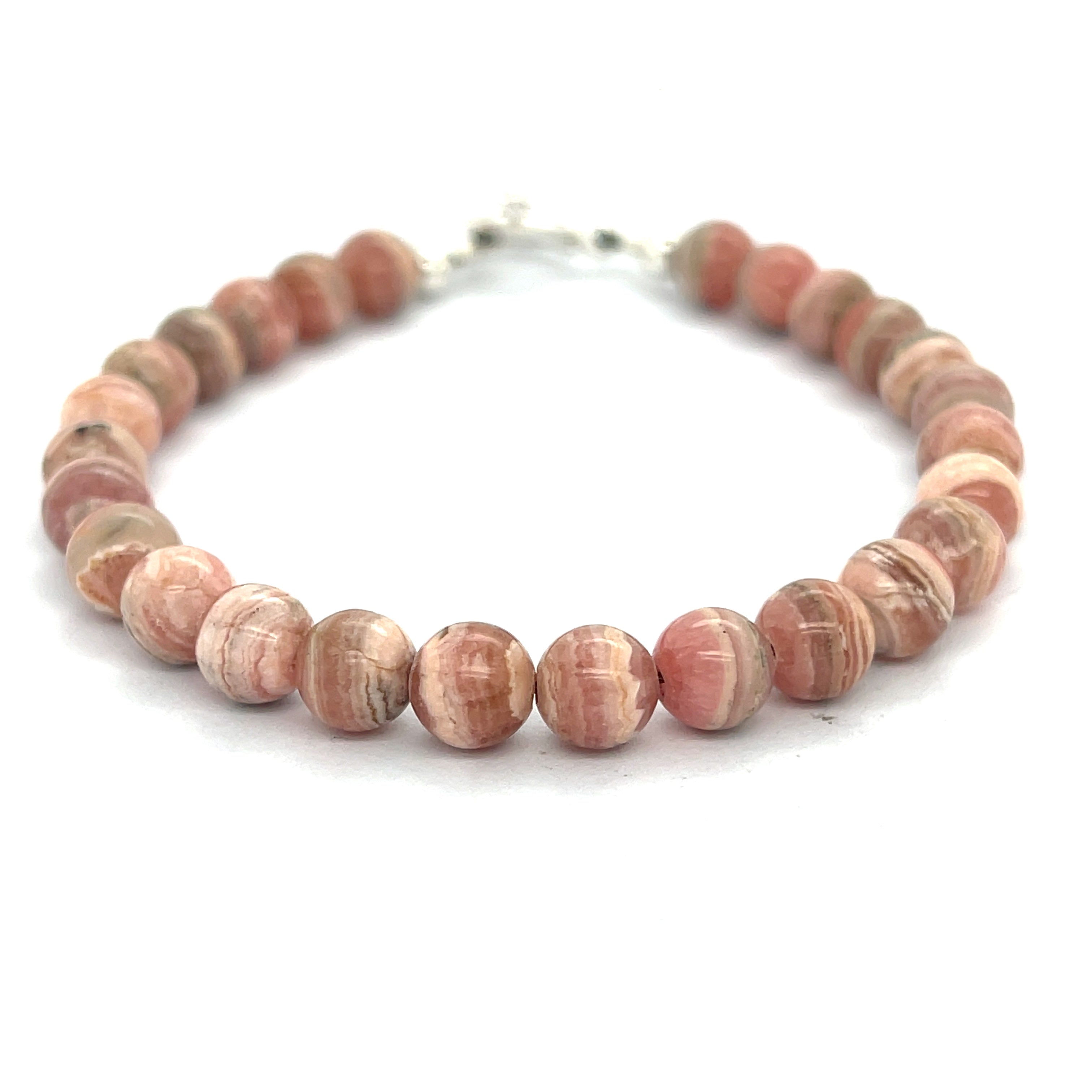 A Rhodochrosite Gemstone 6mm smooth round beaded bracelet with a sterling silver toggle, on a white background, front overview. 
