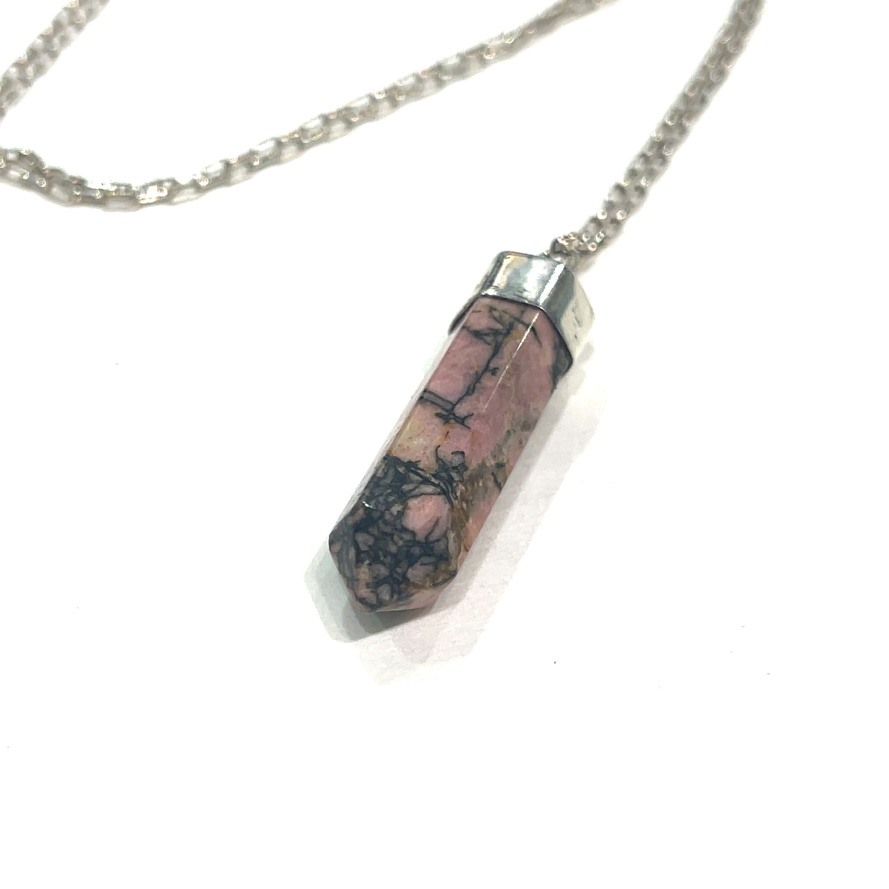 A Rhodonite gemstone pendant on a sterling silver chain. On a white background  front and center,  close up pendant overview. 