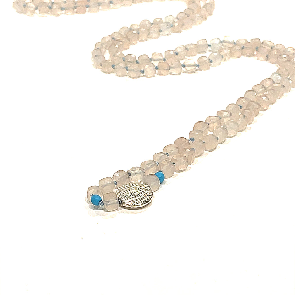 A Rose Quartz and Turquoise knotted necklace with sterling silver beads, on a white background, front, center close-up overview. 