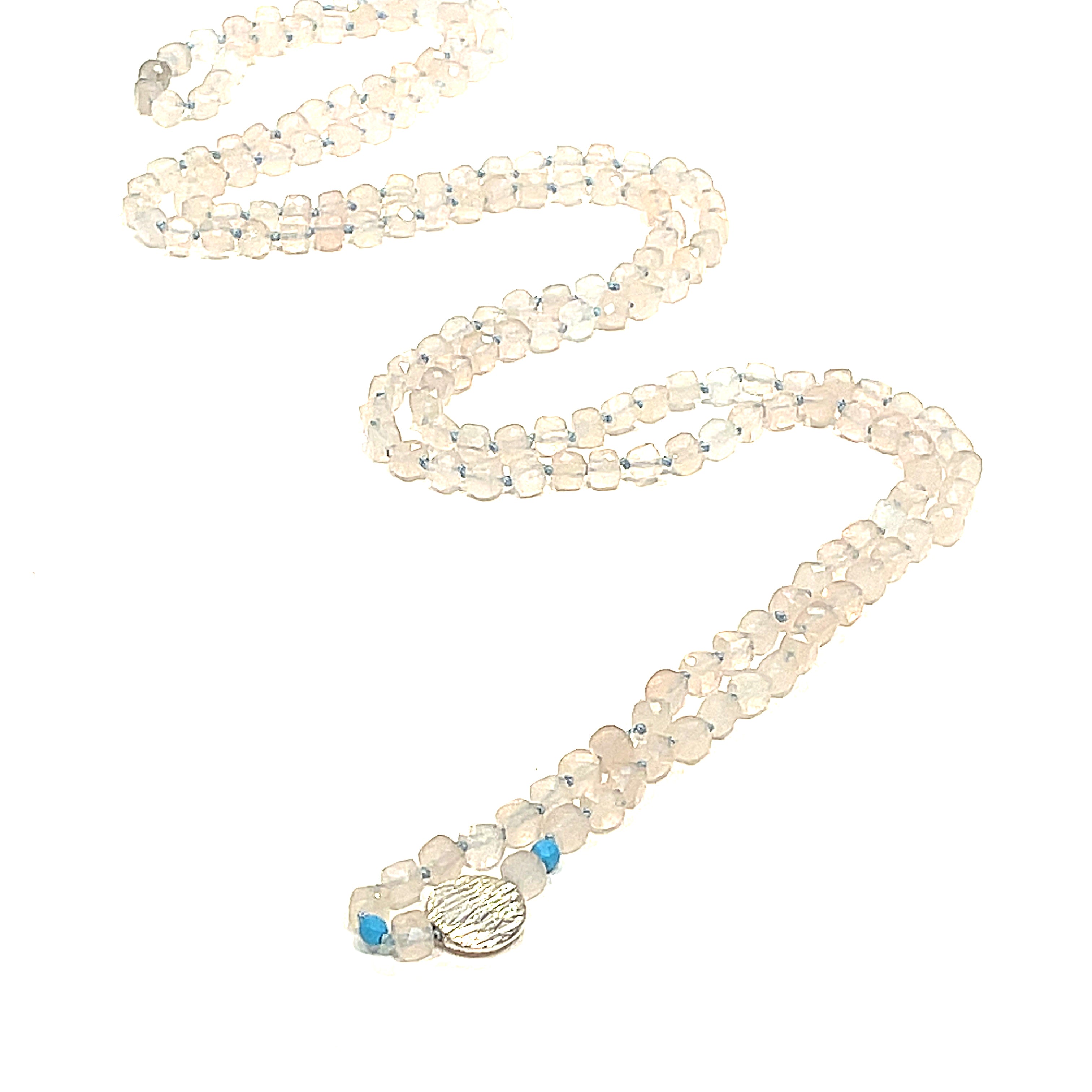 A Rose Quartz and Turquoise knotted necklace with sterling silver beads, on a white background, front, center overview. 