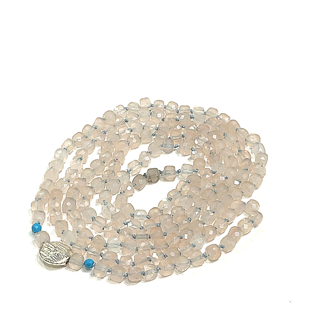 A Rose Quartz and Turquoise knotted necklace with sterling silver beads, on a white background, front, circle close-up overview. 