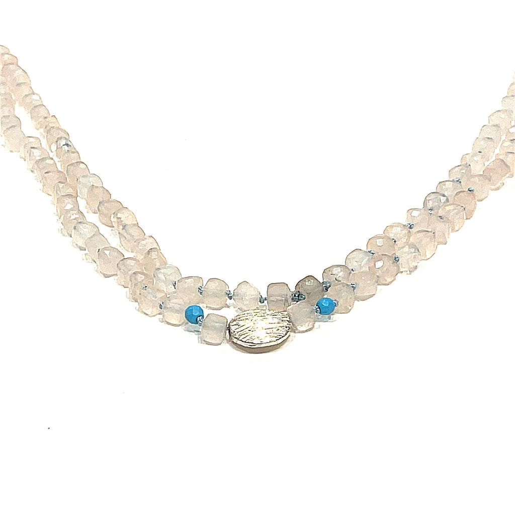 A Rose Quartz and Turquoise knotted necklace with sterling silver beads, on a white background, front, hanging overview. 