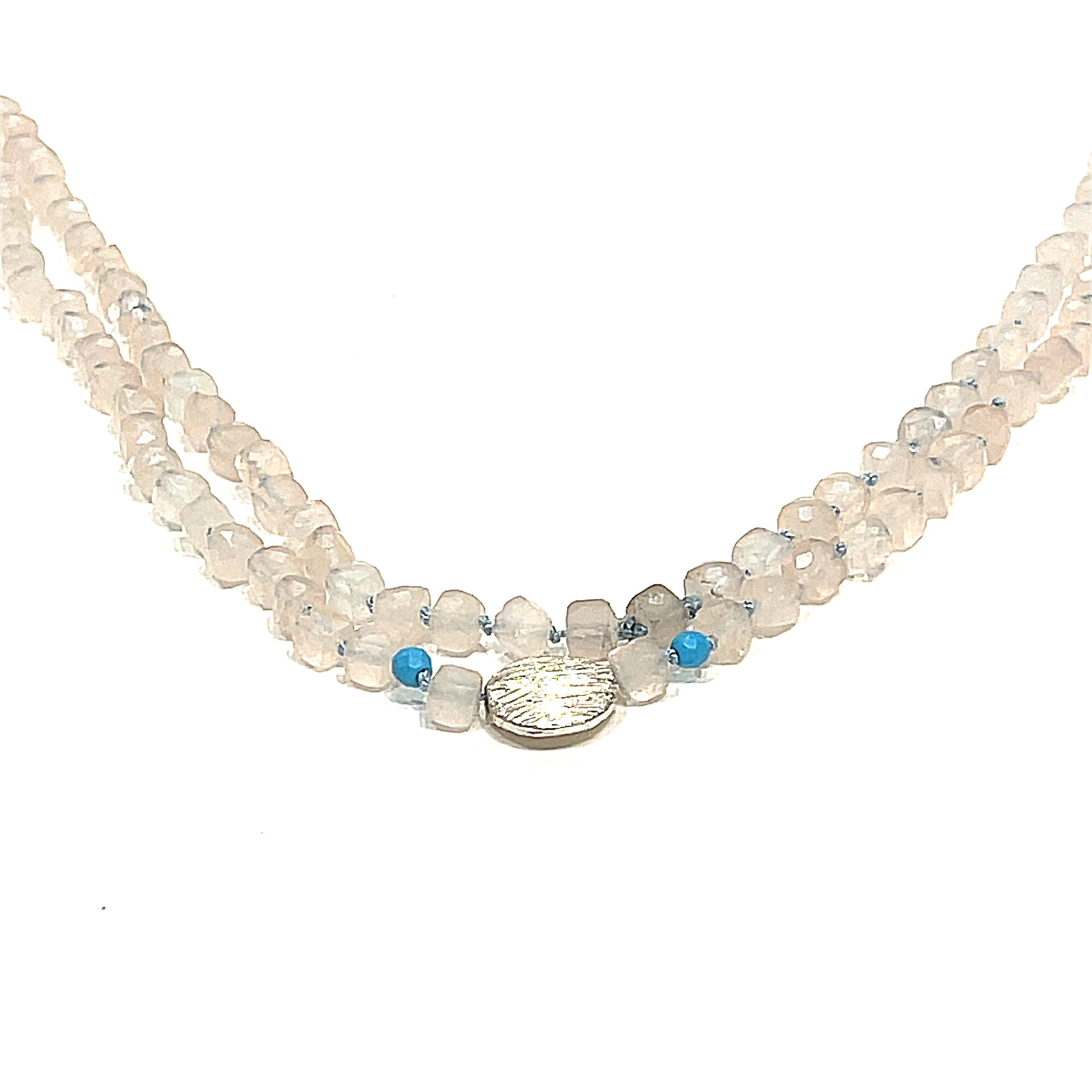 A Rose Quartz and Turquoise knotted necklace with sterling silver beads, on a white background, front, hanging overview. 
