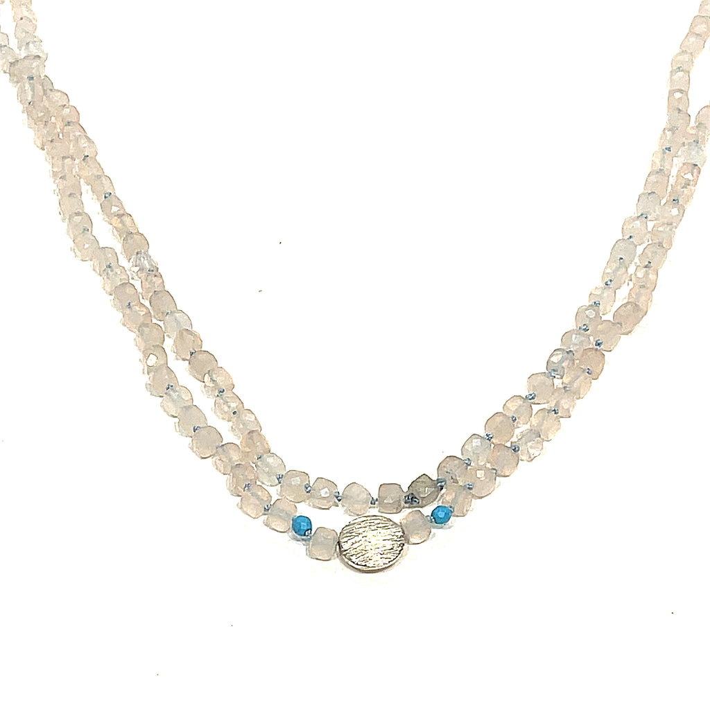 A Rose Quartz and Turquoise knotted necklace with sterling silver beads, on a white background, front, long, hanging close-up overview. 