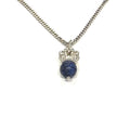 A Sterling Silver Crown Pendant with lapis lazuli gemstone on a white background, long hanging overview. 