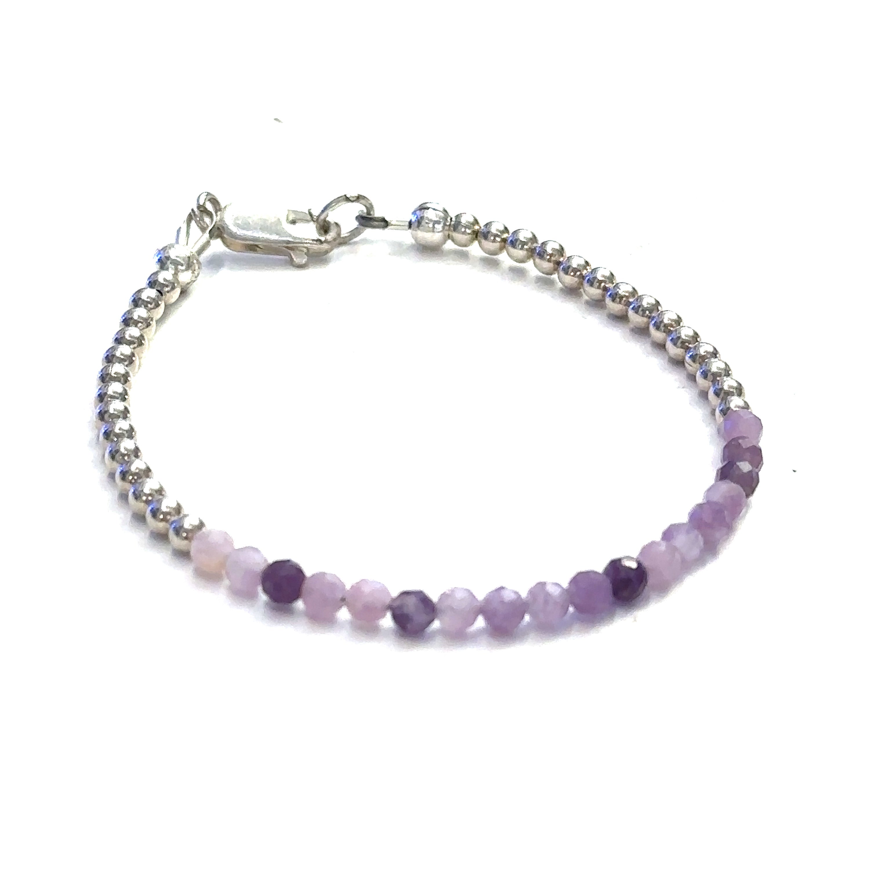 A Sugilite gemstone bracelet with a sterling silver clasp, featuring tiny faceted gemstones in shades of purple and pink on a white background, front view.