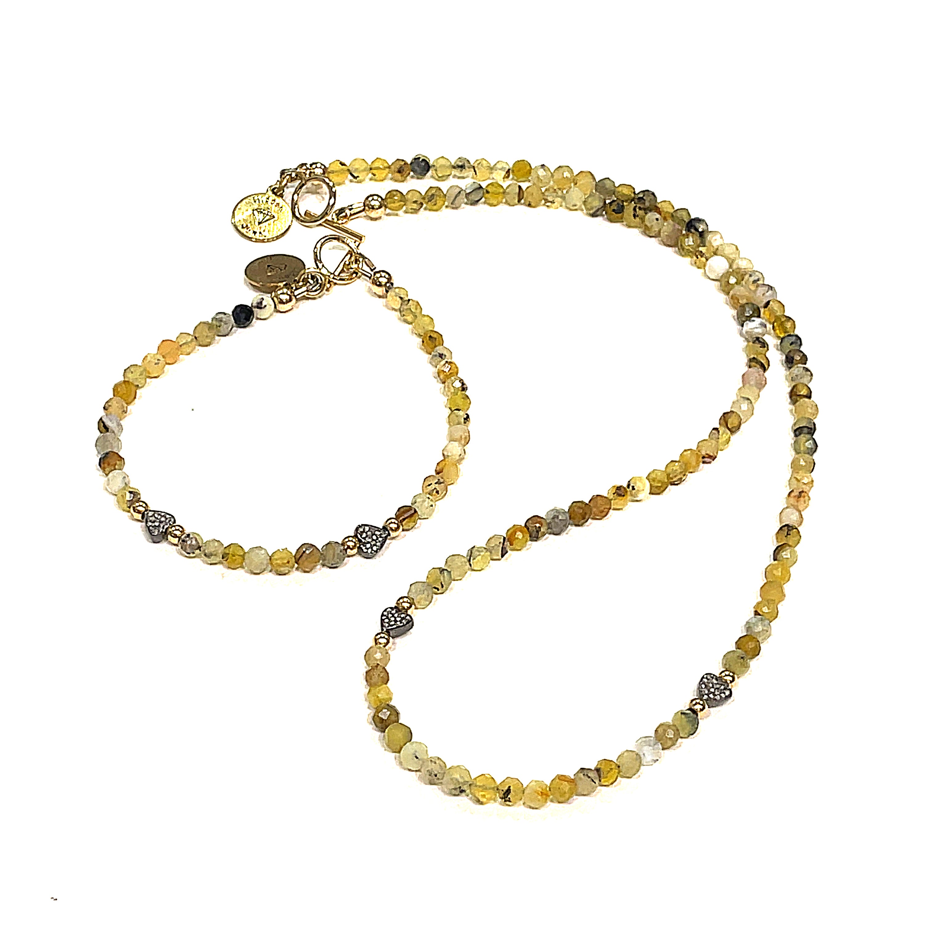 A Yellow Opal gemstone necklace with diamond pave hearts with a matching bracelet placed on a white background front long view.
