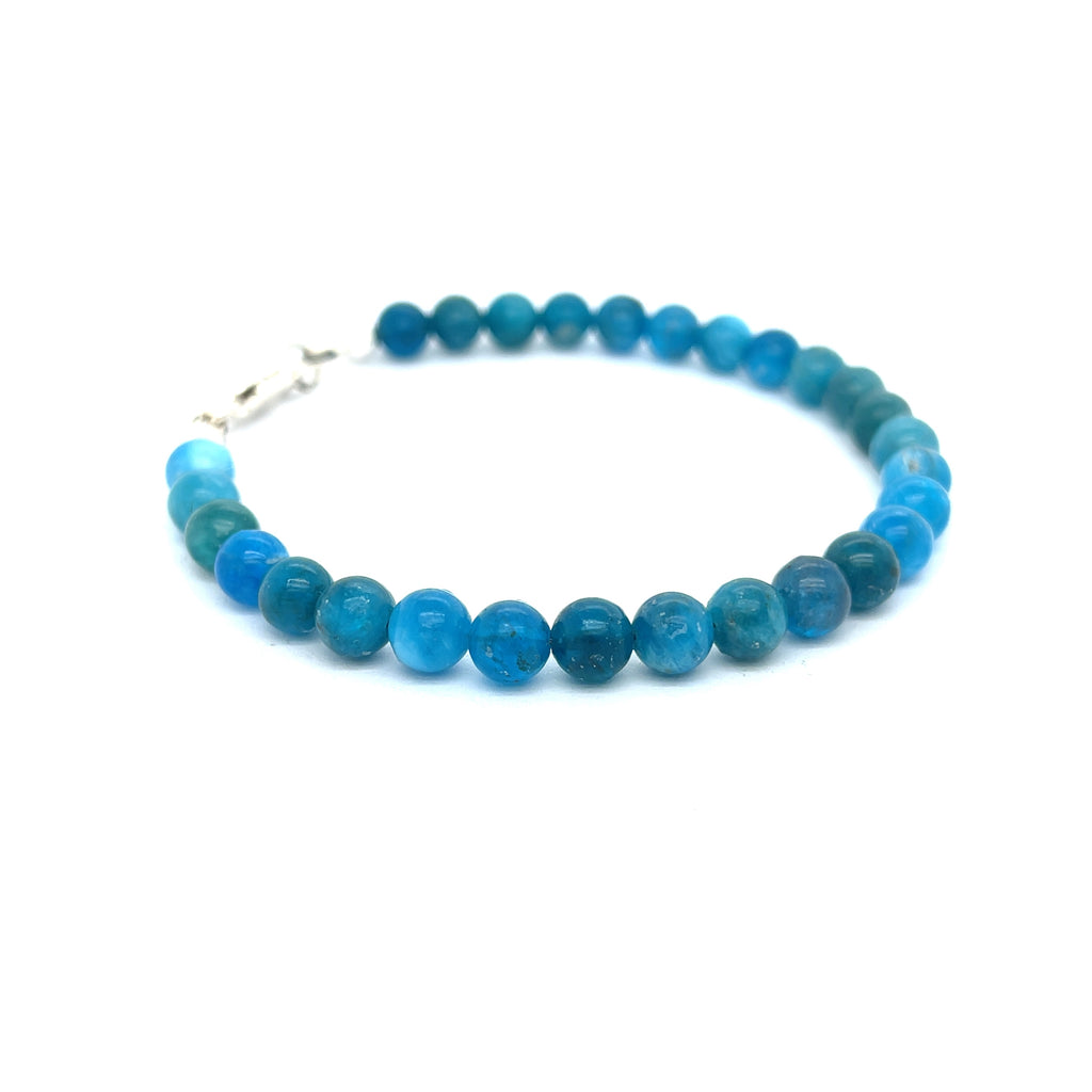 A blue Apatite beaded gemstone bracelet with silver lobster claws, displayed against a white background, front left angle overview.