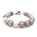 A bracelet made of Edison pearls, featuring a mix of pearl and peal beads, with a sterling silver box clasp and a bezel set labradorite gemstone on a white background, front view.