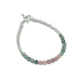 A bracelet with faceted watermelon tourmaline circles and sterling silver beads, featuring a sterling silver toggle clasp, on a white background front overview. 