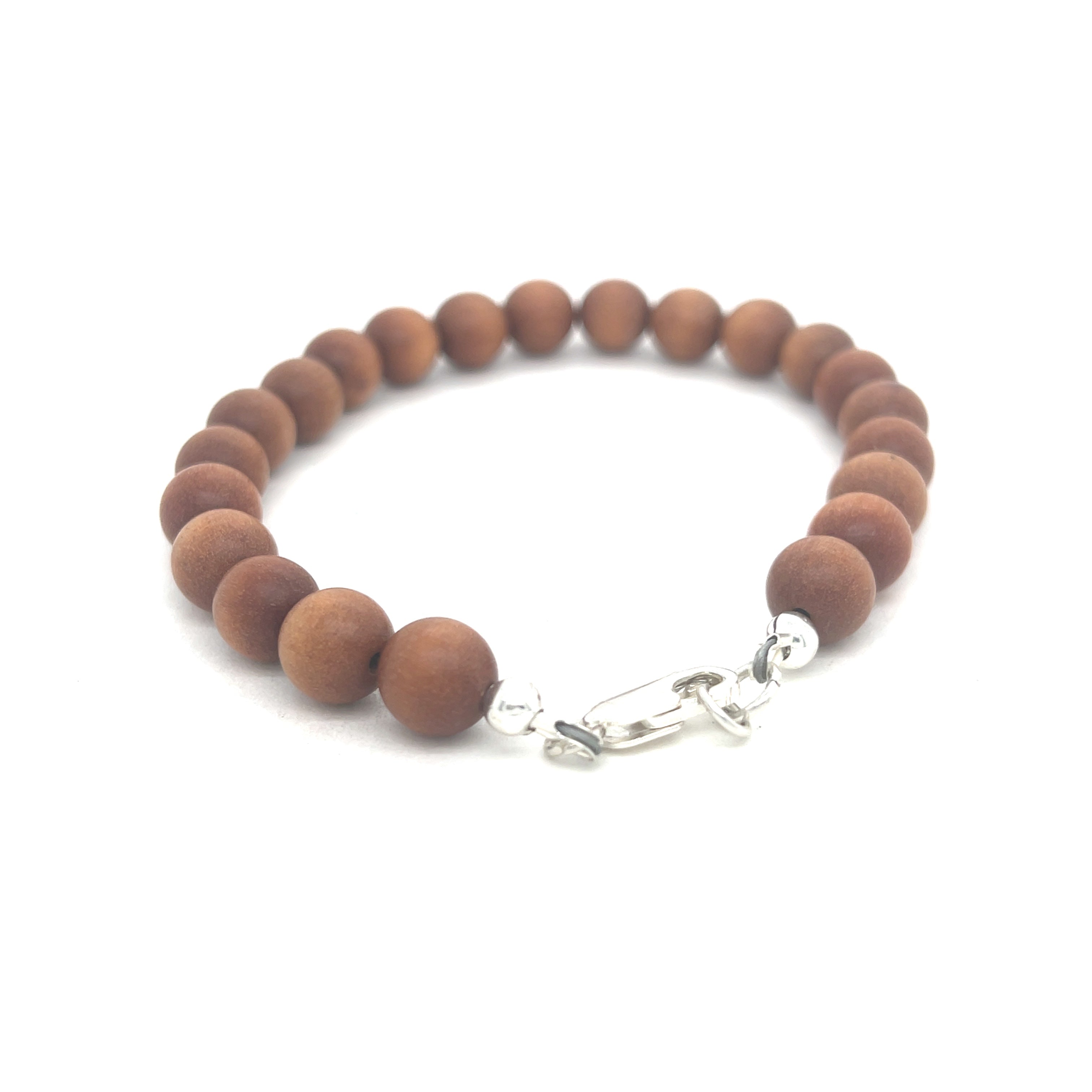 A brown sandalwood beaded bracelet with a sterling silver lobster-claw clasp on a white background, back center overview.