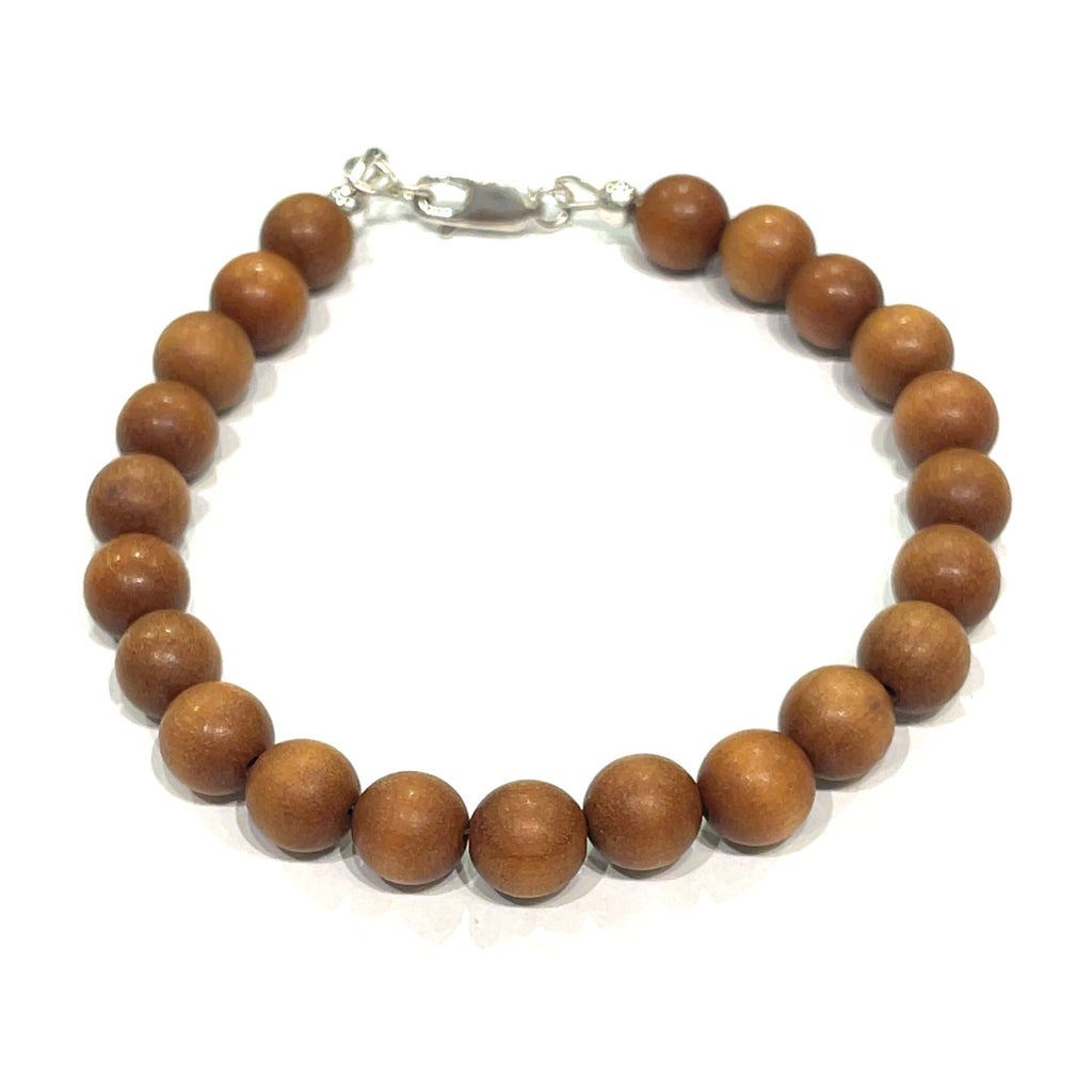 A brown sandalwood beaded bracelet with a sterling silver lobster-claw clasp on a white background, front center overview.