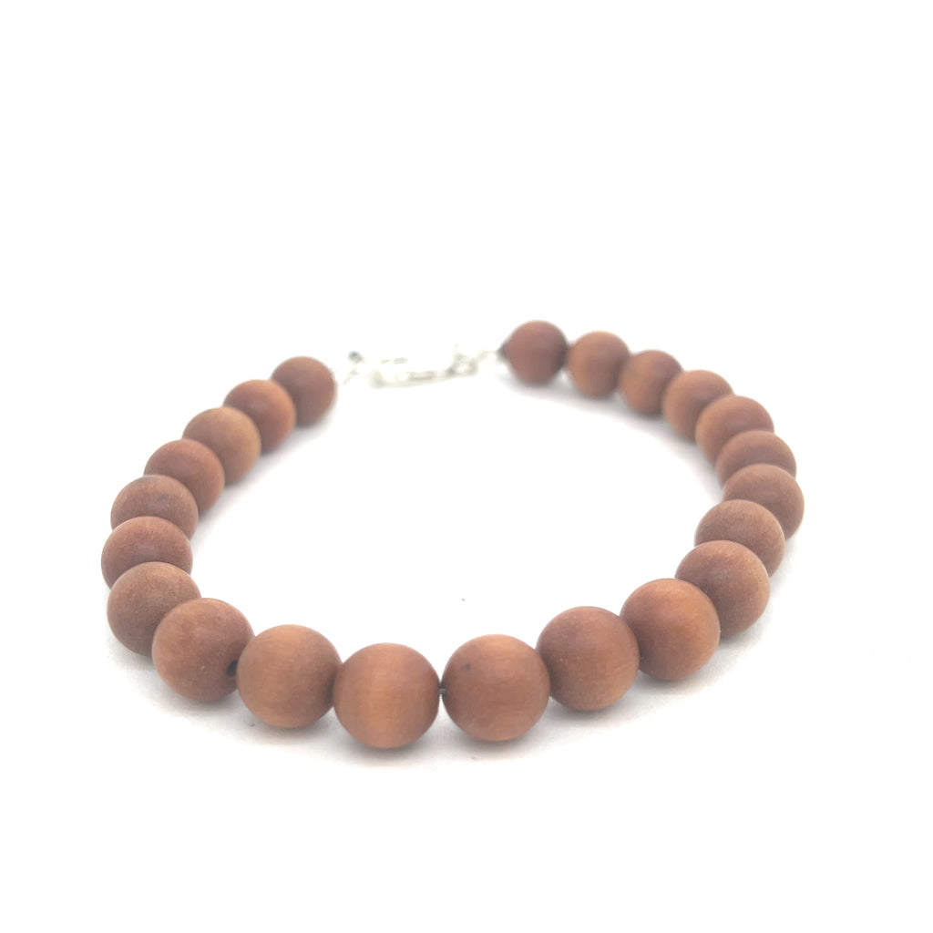 A brown sandalwood beaded bracelet with a sterling silver lobster-claw clasp on a white background, front overview.
